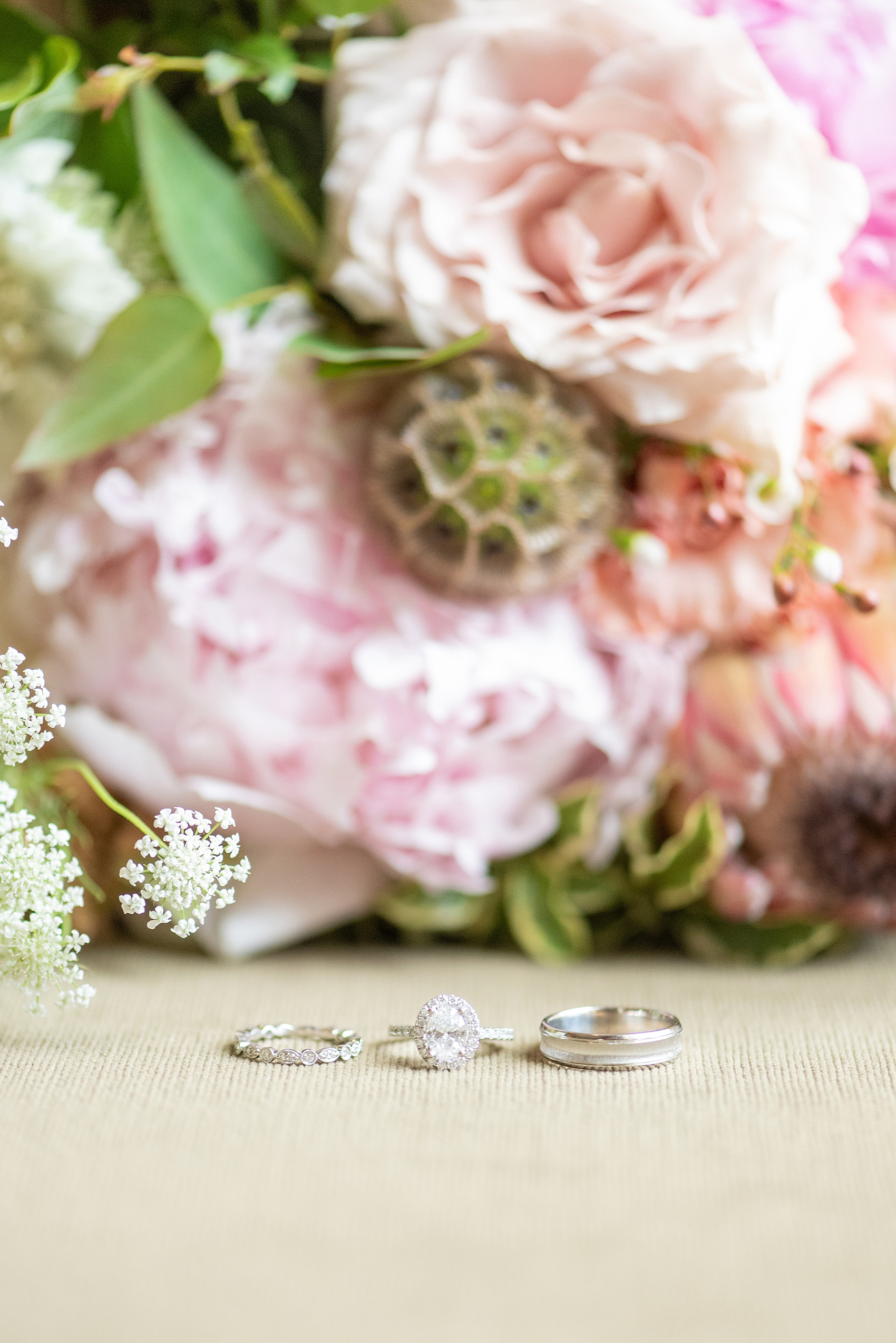 A summer wedding at Olde Mill Inn, NJ. Photos by Mikkel Paige Photography for an event with light pink and blue details. This New Jersey venue is a great option for something not too far from NYC. The bride’s engagement ring was an oval diamond with a halo. Click through for their complete wedding recap! #OldeMillInn #NJwedding #NJweddingphotographer #mikkelpaige #NewJerseyWeddingVenue #NewJerseyWedding #CrossEstateGardens #weddingdetails #rings #weddingrings #ovalengagementring #diamondring