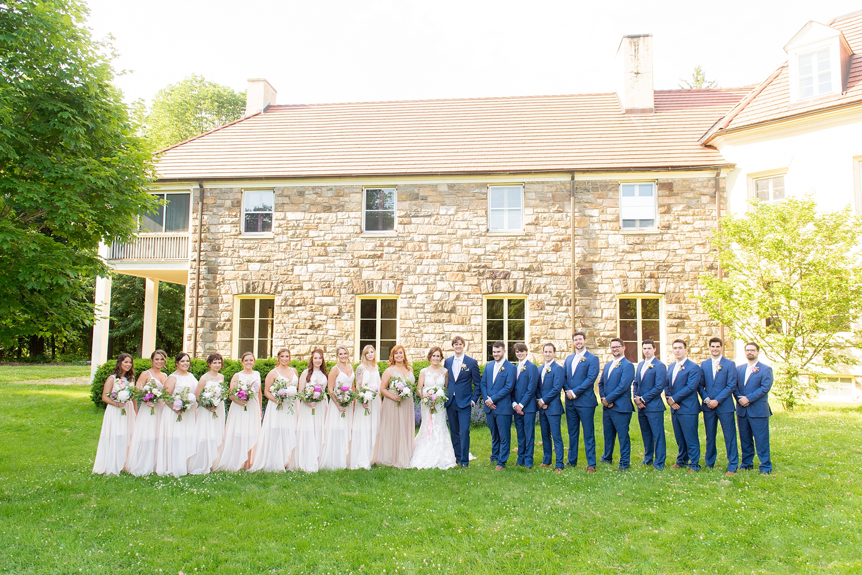 A summer wedding at Olde Mill Inn, NJ. Photos by Mikkel Paige Photography. This New Jersey venue is a great option for an event not too far from NYC. The wedding party photos were at nearby Cross Estate Gardens, a beautiful lush area for bridal party and groomsmen photos. The bridesmaids wore light pink, mis-matched gowns and the guys wore blue suits with pink ties. Click through for their complete wedding recap! #OldeMillInn #NJwedding #NJweddingphotographer #mikkelpaige #NewJerseyWeddingVenue #NewJerseyWedding #CrossEstateGardens #weddingdetails #bridalparty #pinkbridesmaids #mismatcheddresses #bluesuits #groomsmen