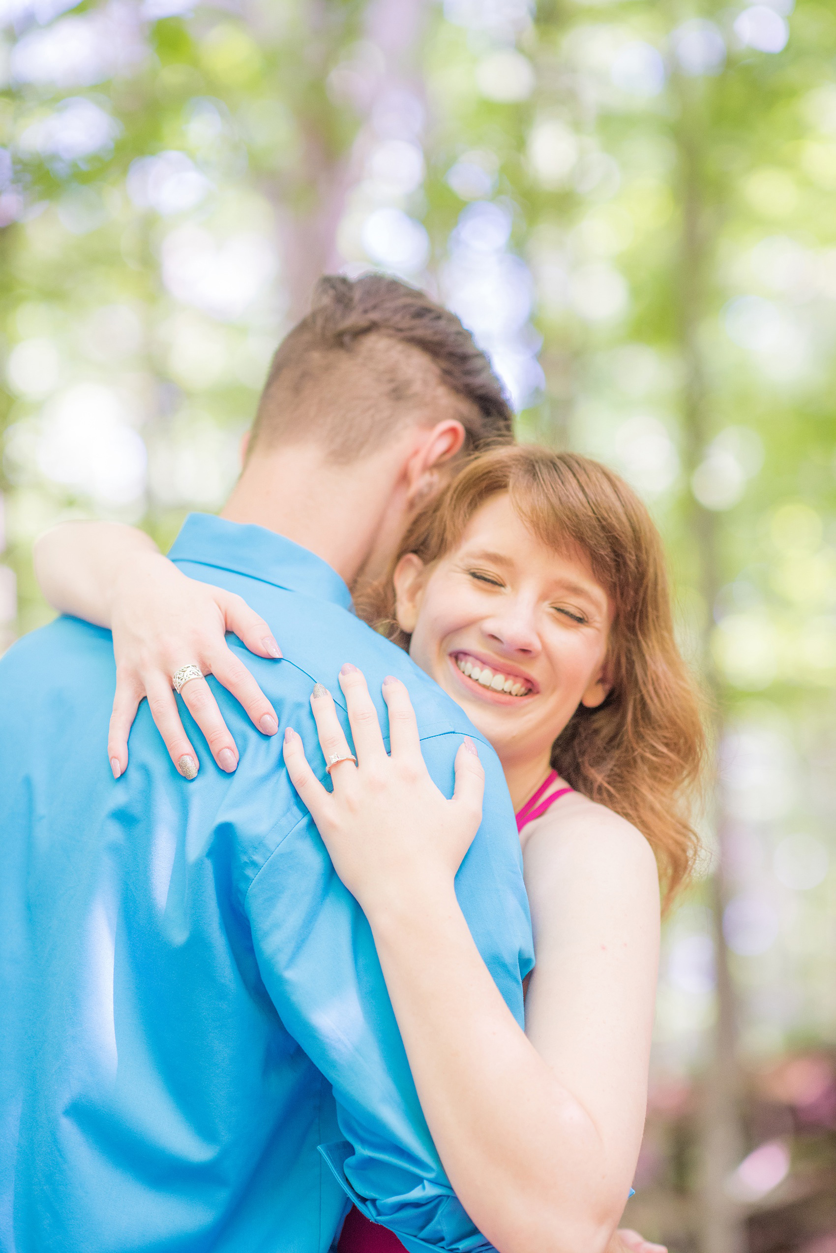 Maryland summer engagement photos by Mikkel Paige Photography. This couple wore semi-formal outfits with the bride in a beautiful, sexy back fuchsia pink gown and the groom in a blue button down and grey pants. Their elegant outdoor park pictures were perfect for the season! Click through to see more from their romantic pictures in the woods! #mikkelpaige #summerengagementphotos #marylandengagementphotos #marylandweddingphotographer #parkengagementsession #engagementphotooutfitideas #engagementphotos #savethedatephotos 