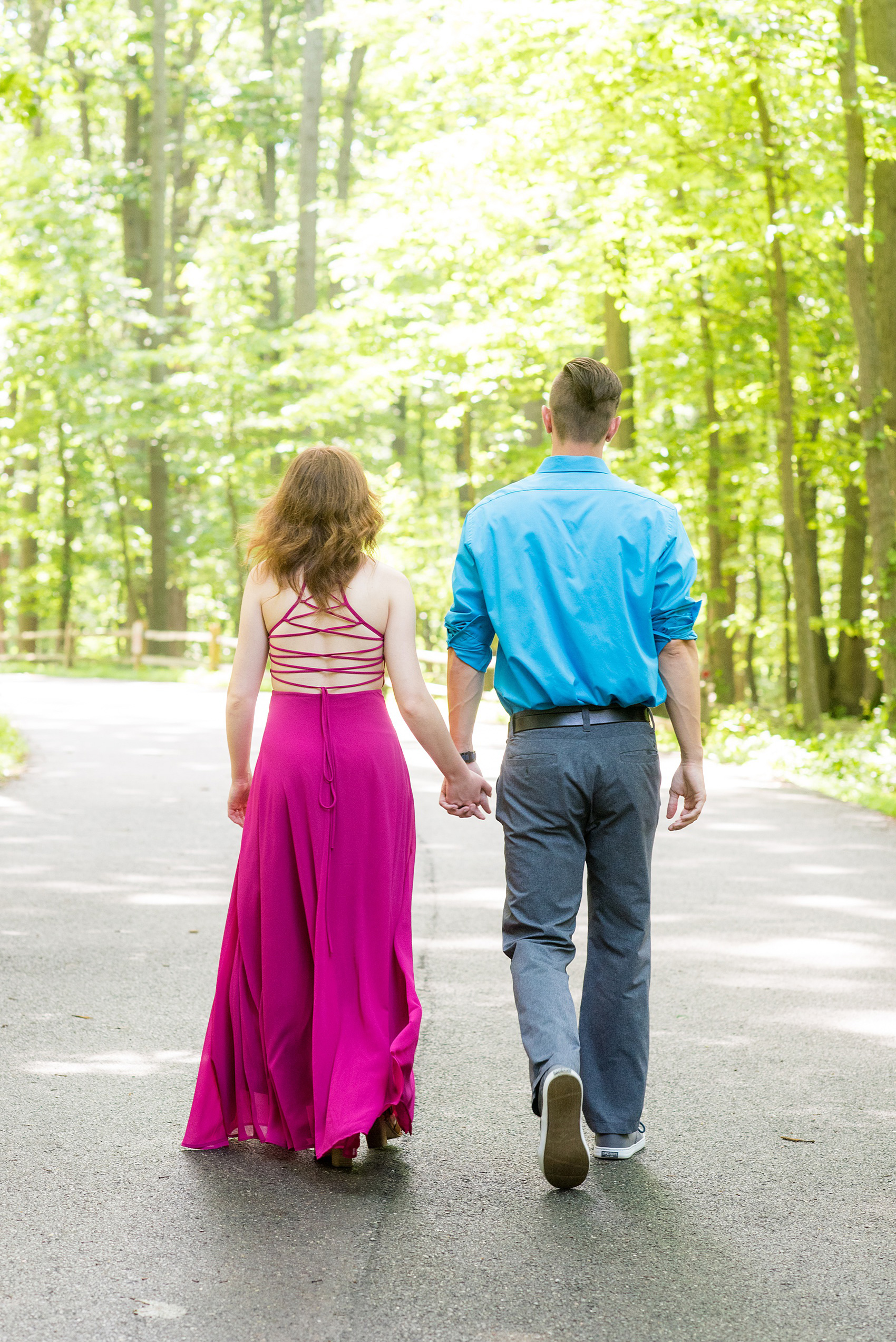 Maryland summer engagement photos by Mikkel Paige Photography. This couple wore semi-formal outfits with the bride in a beautiful, sexy back fuchsia pink gown and the groom in a blue button down and grey pants. Their elegant outdoor park pictures were perfect for the season! Click through to see more from their romantic pictures in the woods! #mikkelpaige #summerengagementphotos #marylandengagementphotos #marylandweddingphotographer #parkengagementsession #engagementphotooutfitideas #engagementphotos #savethedatephotos 