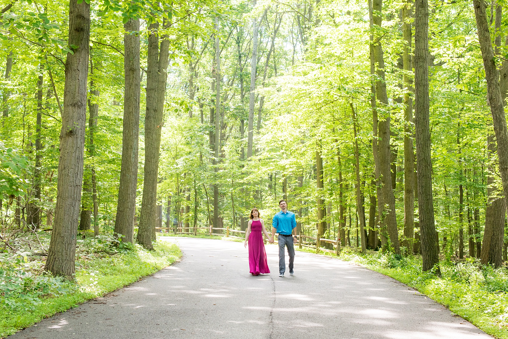 Maryland summer engagement photos by Mikkel Paige Photography. This couple wore semi-formal outfits with the bride in a beautiful, sexy back fuchsia pink gown and the groom in a blue button down and grey pants. Their elegant outdoor park pictures were perfect for the season! Click through to see more from their romantic pictures in the woods! #mikkelpaige #summerengagementphotos #marylandengagementphotos #marylandweddingphotographer #parkengagementsession #engagementphotooutfitideas #engagementphotos #savethedatephotos 