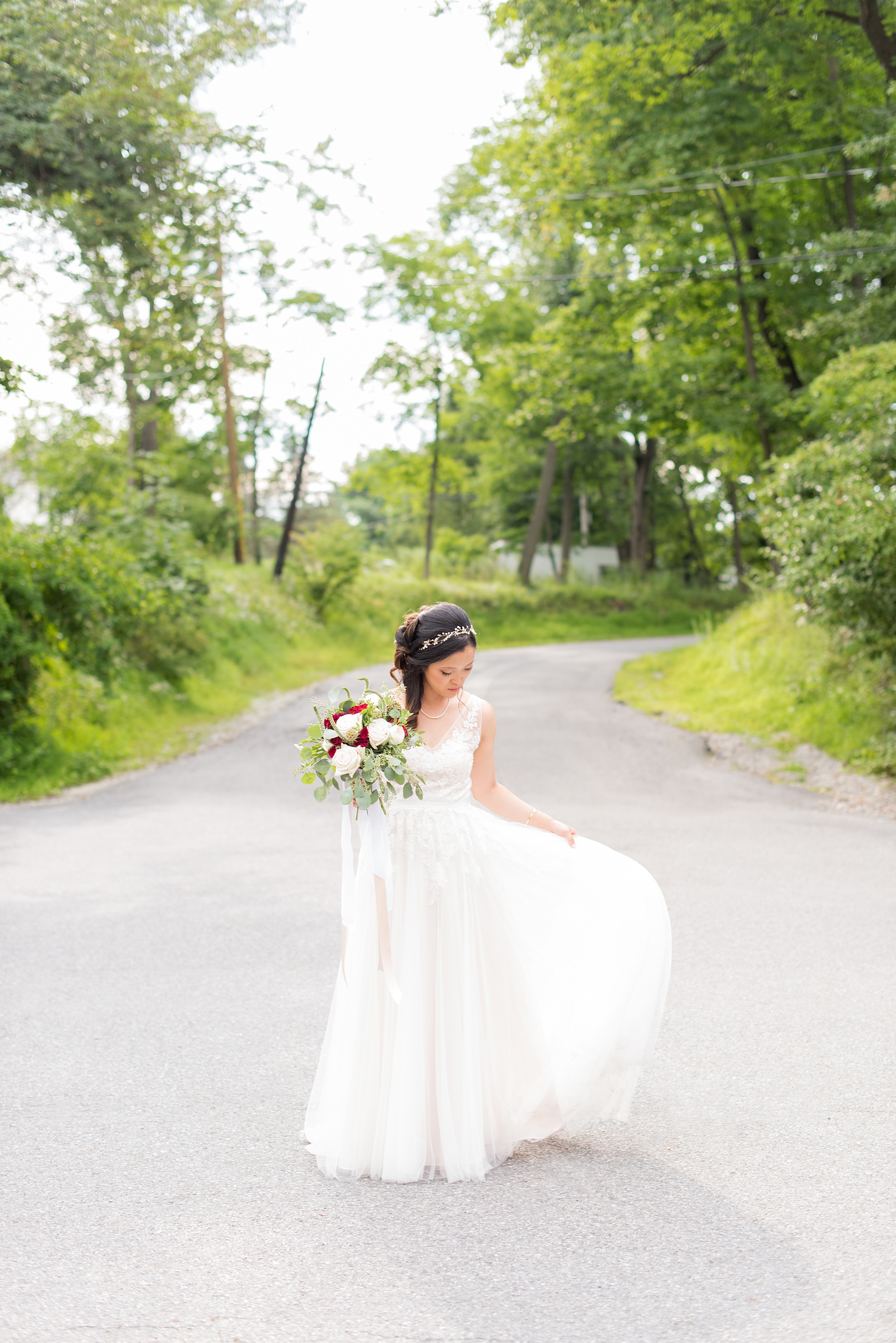 Wedding photos at Crabtree's Kittle House in Chappaqua, New York by Mikkel Paige Photography. The bride wore a summery lace and tulle gown from BHLDN for her wedding and held a bouquet with red and white flowers at this historic Westchester County venue very close to NYC. Click through to see more detail photos from this gorgeous day! #mikkelpaige #CrabtreesKittleHouse #WestchesterWeddingVenues #WestchesterWedding #summerwedding #weddingdetails #bride #weddingdetails #BHLDN #laceandtullegown #summerweddingdress #redandwhitebouquet