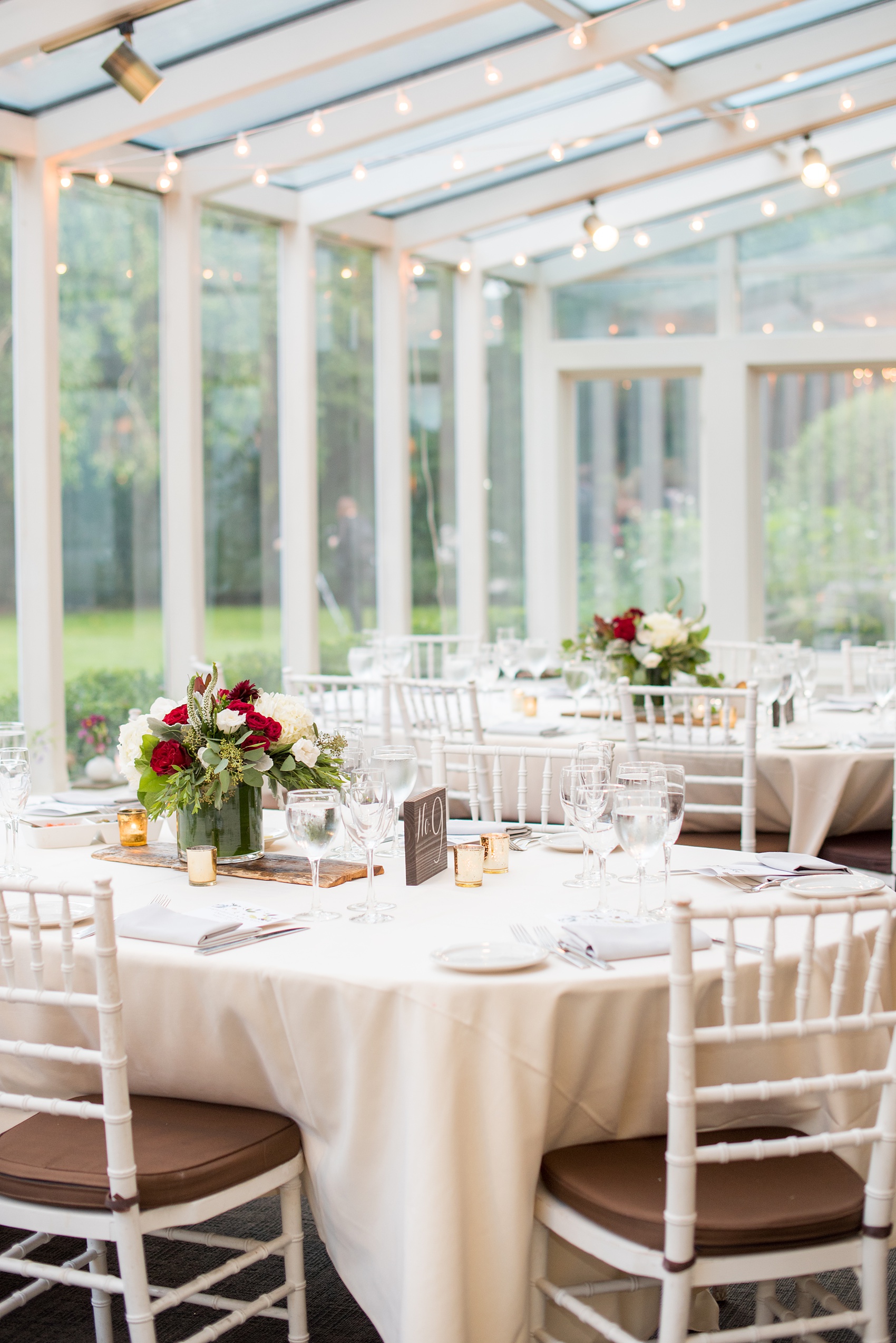 Wedding photos at Crabtree's Kittle House in Chappaqua, New York by Mikkel Paige Photography. The indoor reception was in a historic home, close to NYC in Westchester county. The red and white floral centerpieces were placed under twinkle market lights. Click through for more reception inspiration from this beautiful summer wedding! #mikkelpaige #CrabtreesKittleHouse #WestchesterWeddingVenues #WestchesterWedding #summerwedding #redandwhiteflowercenterpieces #redandwhiteflowers #marketlights