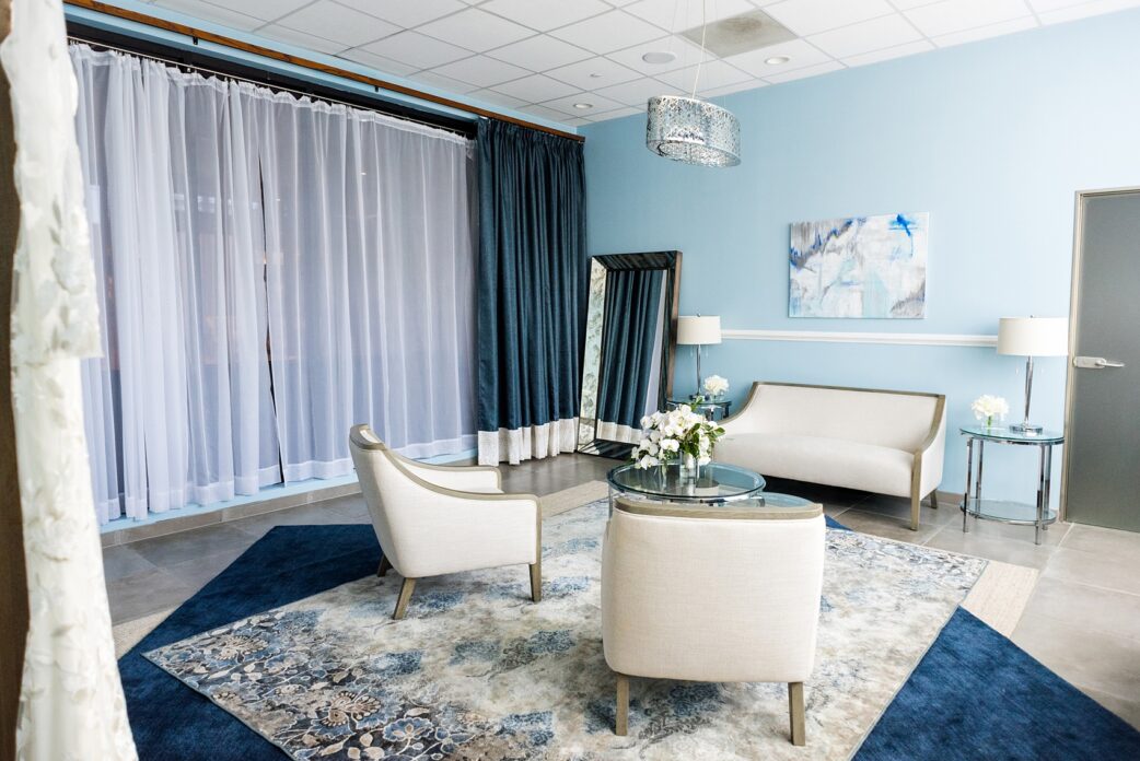 Downtown Raleigh wedding venue photos of Vidrio on Glenwood South, and their beautiful new bridal suite. Blue hues and neutral furniture are framed by paintings and a full length mirror in this beautiful space. #MikkelPaige #Vidrio #DowntownRaleigh #RaleighWeddingVenues
