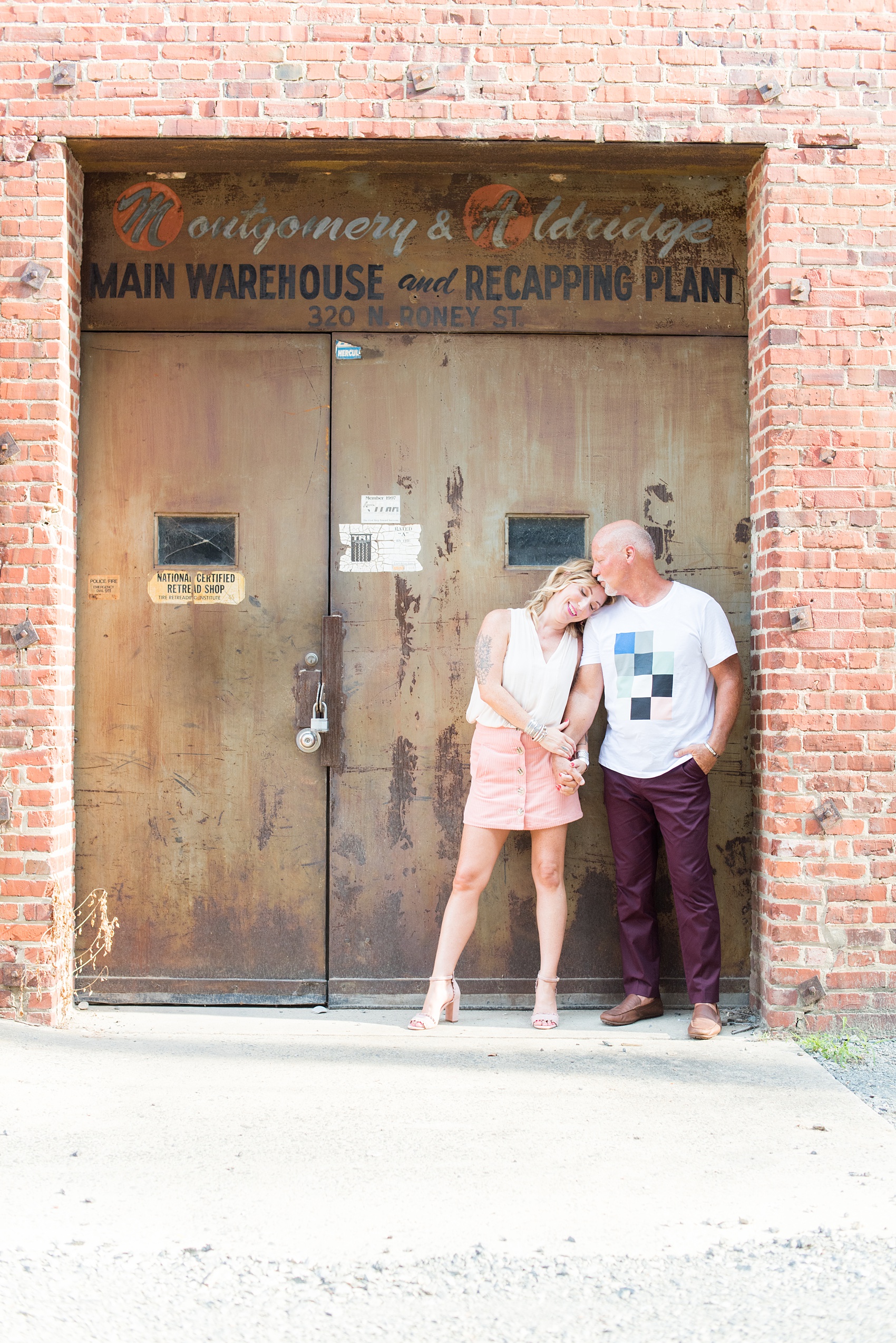 Urban engagement photos in downtown Durham, North Carolina, by Mikkel Paige Photography. The bride has a diamond engagement ring with a halo square and round center stone and filigree detail on the band. #DurhamWeddingPhotographer #RaleighWeddingPhotographer #DurhamEngagementPhotos #urbanengagementphotos #cityengagementsession #cityengagementphotos #filigree #engagementring #halosetting