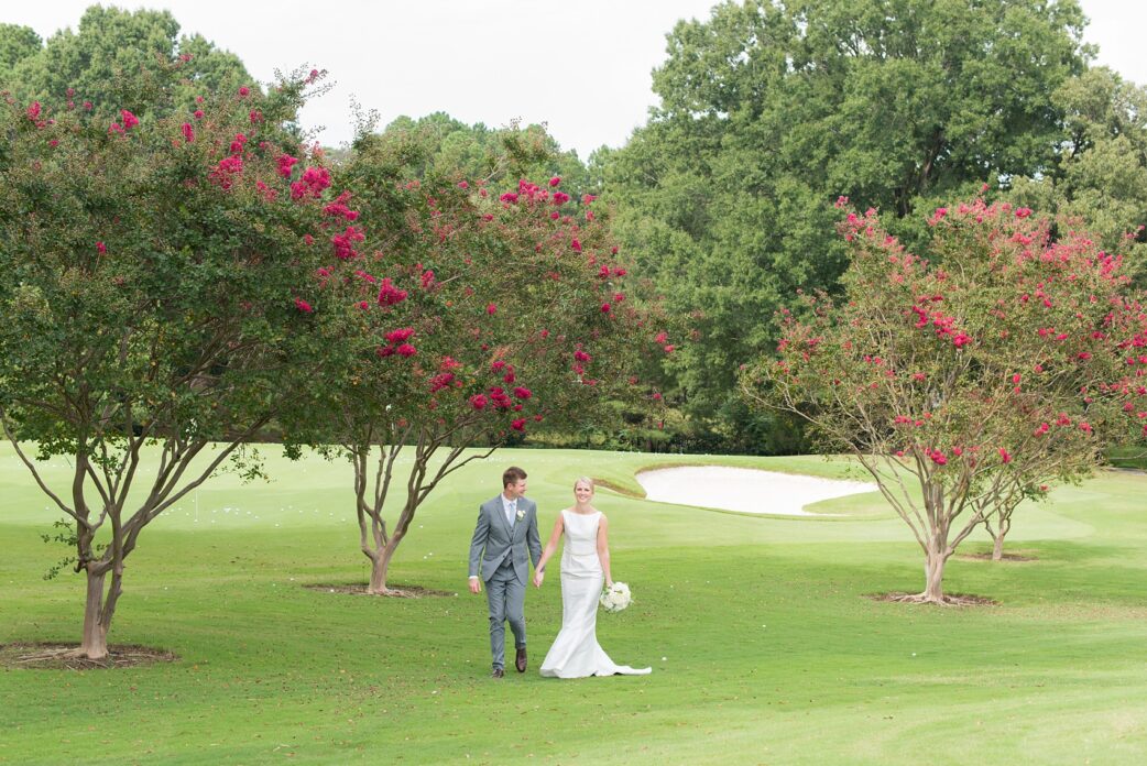 Pictures by Mikkel Paige Photography of a wedding in Durham, North Carolina. The bride carried hydrangea flowers for the garden-like golf course photos with her groom, who wore a grey suit. Her low-back gown and up-do hair twists were beautiful! Click through to the website post for complete details and more inspiration! #durhamNC #northcarolinawedding #golfcoursewedding #CountryClub #DurhamWedding #summerwedding #weddinggown #lowbackweddinggown #brideandgroom #firstlook