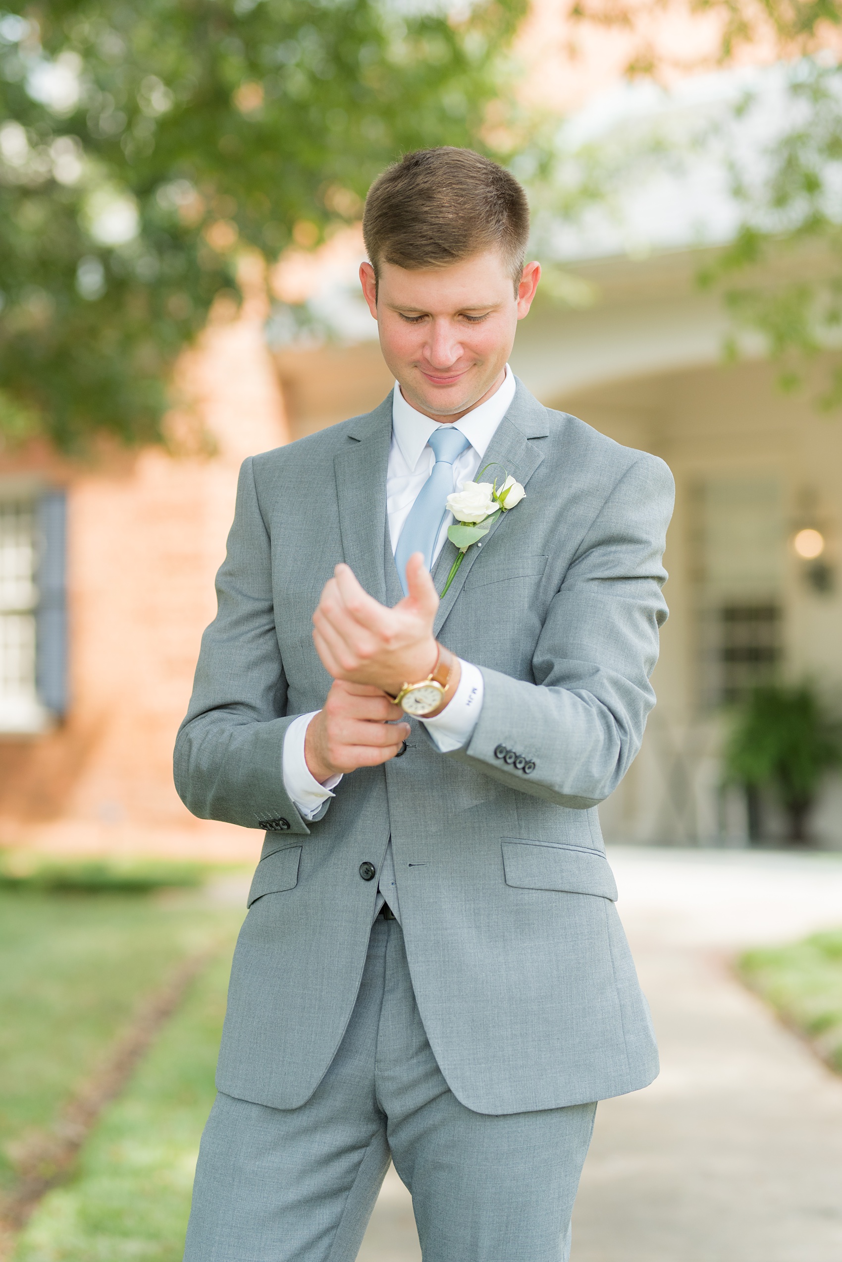 Pictures by Mikkel Paige Photography of a wedding in Durham, North Carolina. The groom wore a white rose boutonniere with his grey suit and blue tie while the bride carried hydrangea flowers for the garden-like golf course photos together. Click through to the website post for complete details and more inspiration! #durhamNC #northcarolinawedding #golfcoursewedding #CountryClub #DurhamWedding #summerwedding #brideandgroom #groom #bluetie