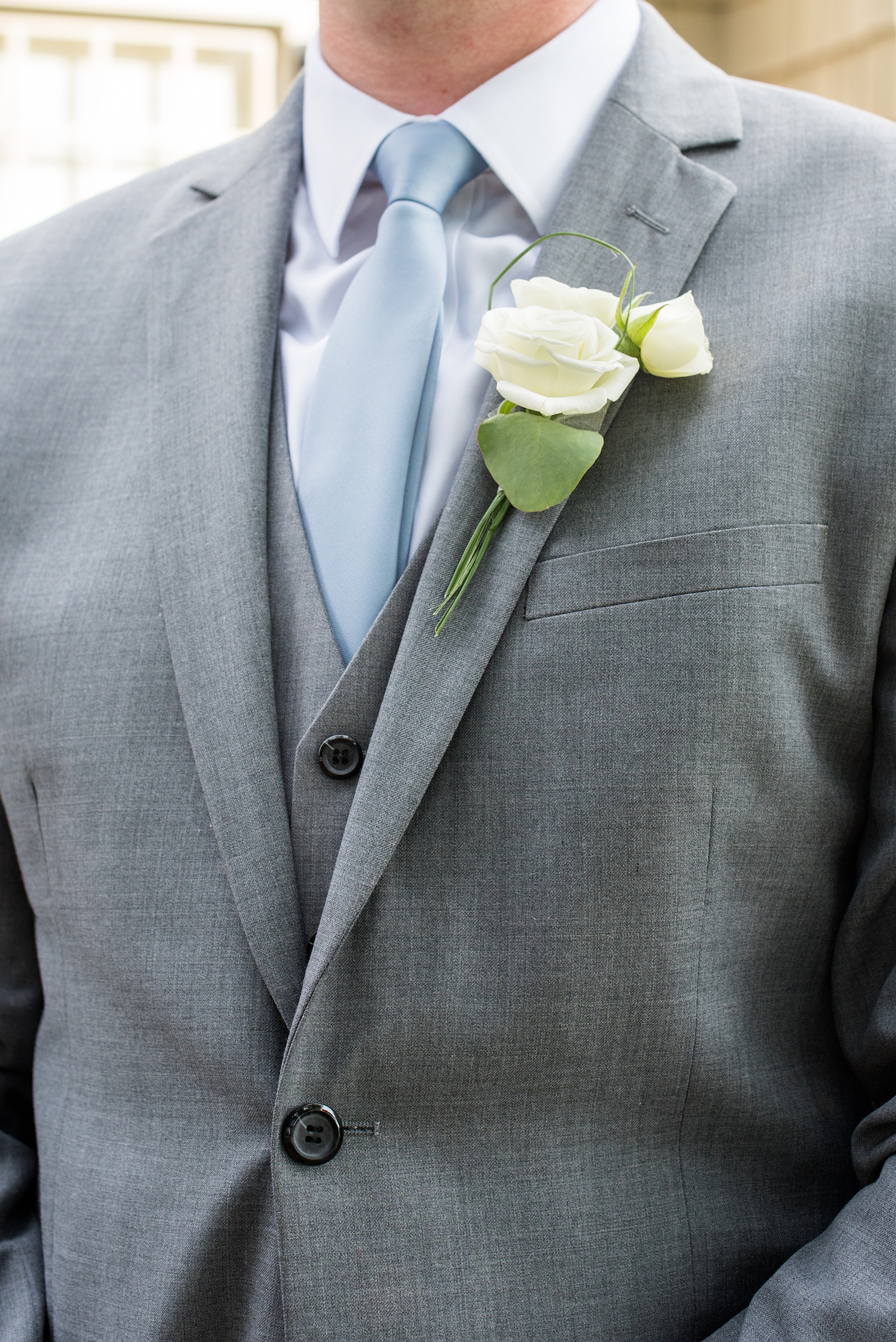 Pictures by Mikkel Paige Photography of a wedding in Durham, North Carolina. The groom wore a white rose boutonniere for the day on his grey suit. This beautiful golf course photo ideas with the bridal party, and bride will provide endless inspiration! Click through to our website for the complete post and details. #durhamNC #northcarolinawedding #southernwedding #golfcoursewedding #CountryClubWedding #groomsuit #boutonniere #DurhamWedding #summerwedding