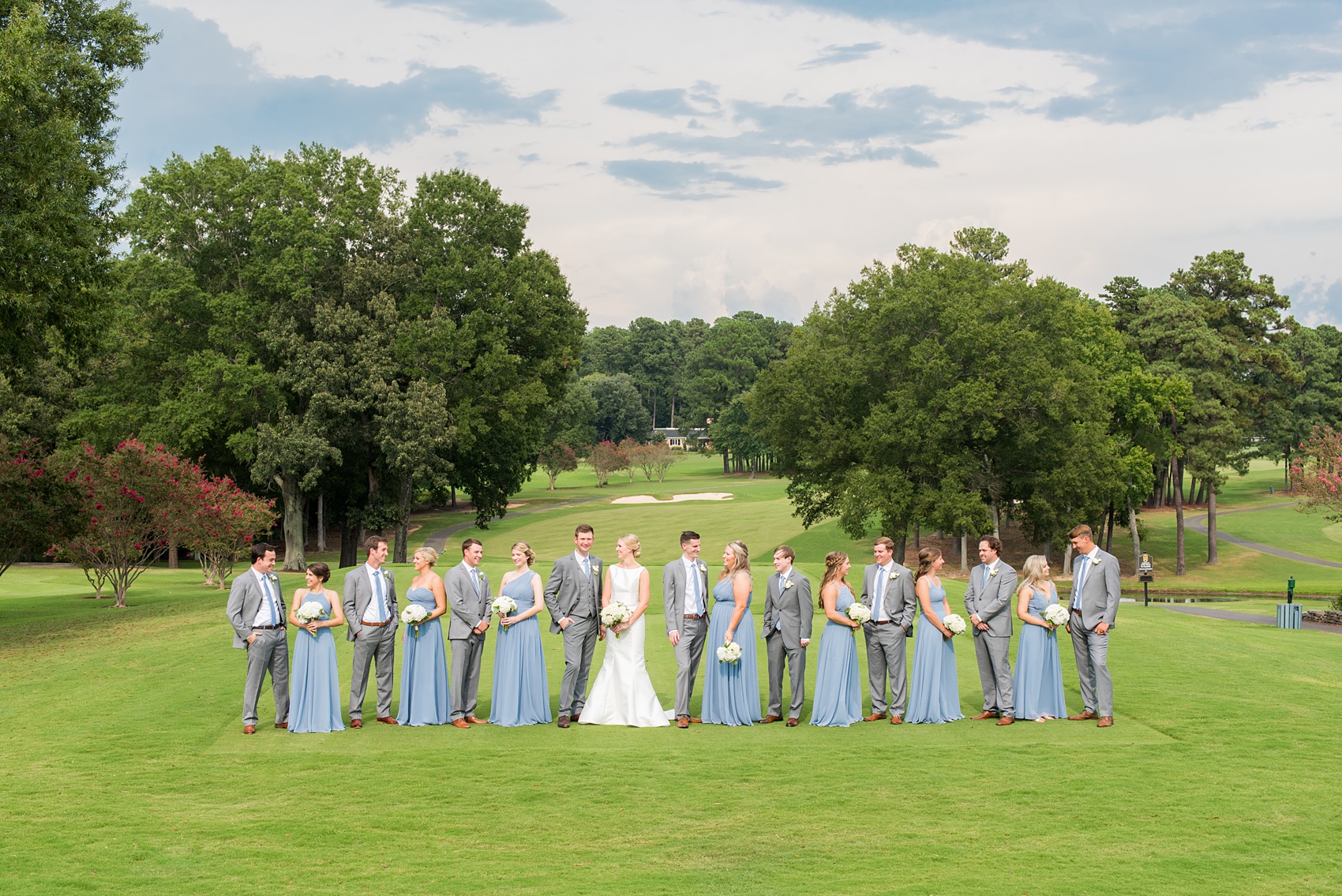 Pictures by Durham wedding photographer, Mikkel Paige Photography, in North Carolina. The beautiful white flowers from the days events, pretty garden-like golf course at Croasdaile Country Club and various photo ideas with the bridesmaids in blue and bride in a low-back gown will inspire you! Click through to our website for the complete post and details. #durhamNC #northcarolinawedding #southernwedding #golfcoursewedding #CountryClubWedding #bluebridesmaids #DurhamWedding #summerwedding