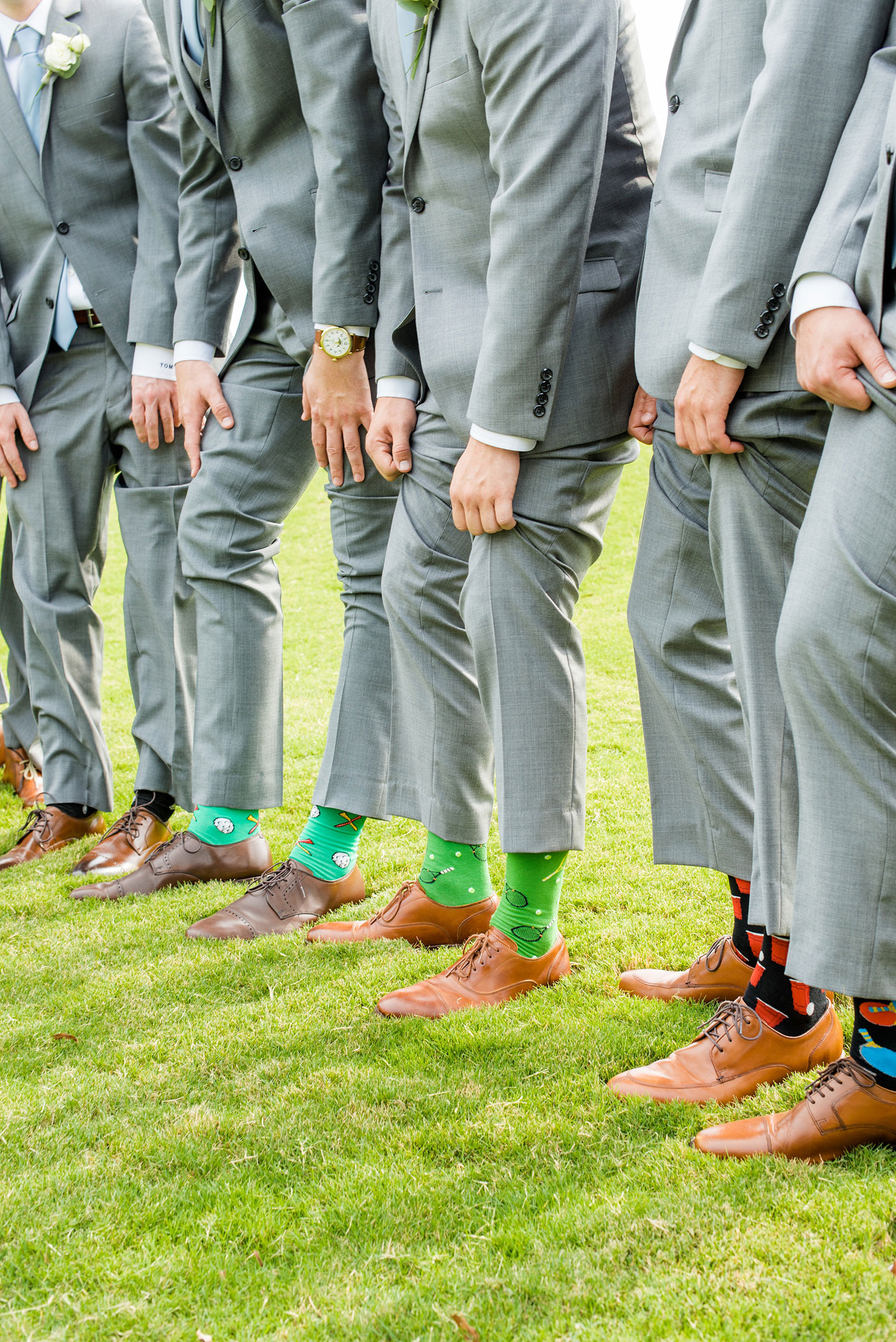 Pictures by Mikkel Paige Photography of a wedding in Durham, North Carolina. The groom wore a white rose boutonniere with grey suit and blue tie while for the garden-like golf course photos together. He gifted all his best friends unique socks for a special detail! Click through to the website post for complete inspiration! #durhamNC #northcarolinawedding #golfcoursewedding #CountryClub #DurhamWedding #summerwedding #groom #blueties #groomsmen #greysuits