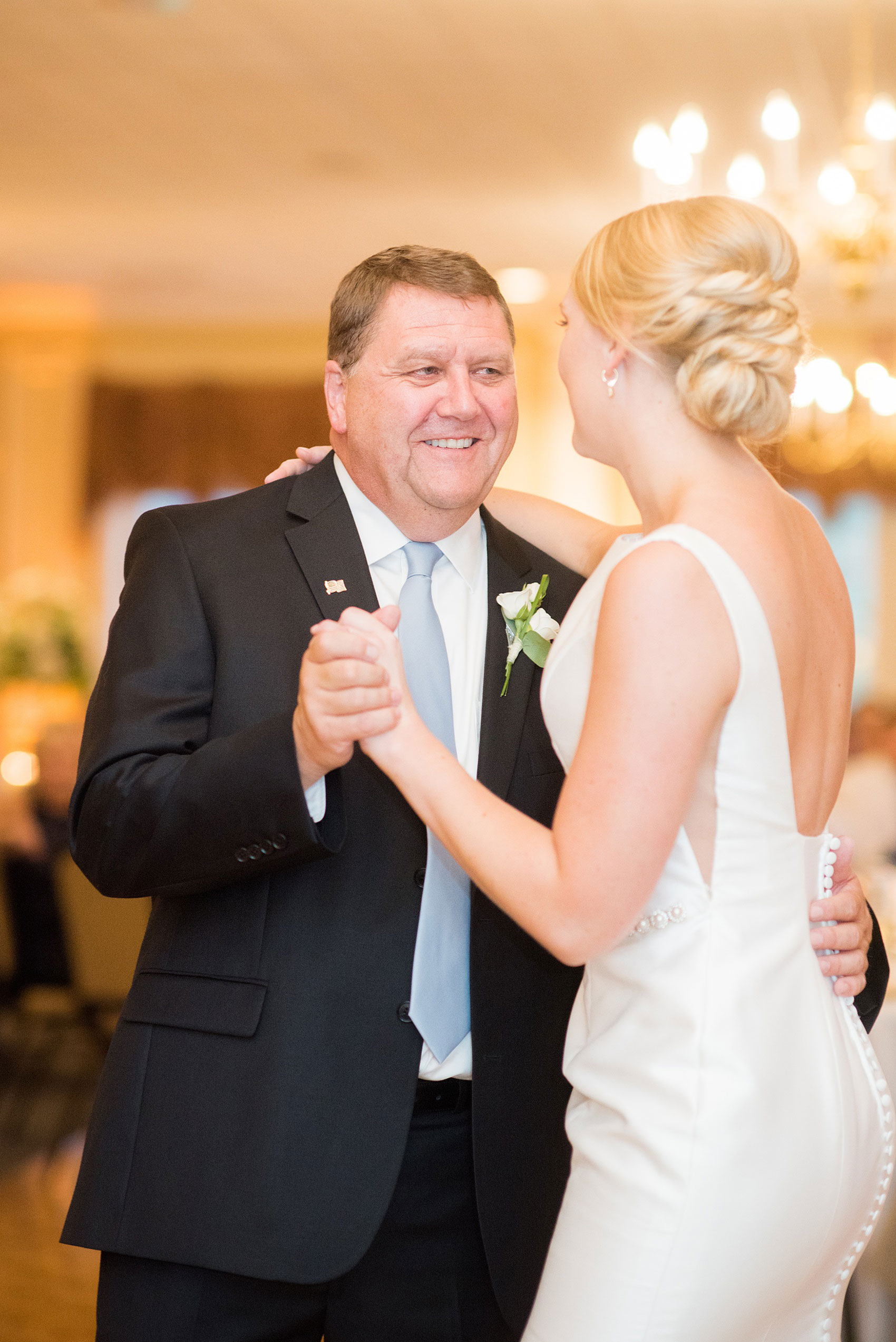 Pictures by Mikkel Paige Photography of a wedding in Durham, North Carolina. The beautiful hydrangea flowers from the day’s events adorned the party room that overlooked a pretty garden-like golf course. The father-of-the-bride shared a special dance with his daughter before a reception glowstick exit. Click through to our website for the complete post! #durhamNC #northcarolinawedding #golfcoursewedding #CountryClub #DurhamWedding #summerwedding #weddingexit #glowsticks #fatherdaughterdance