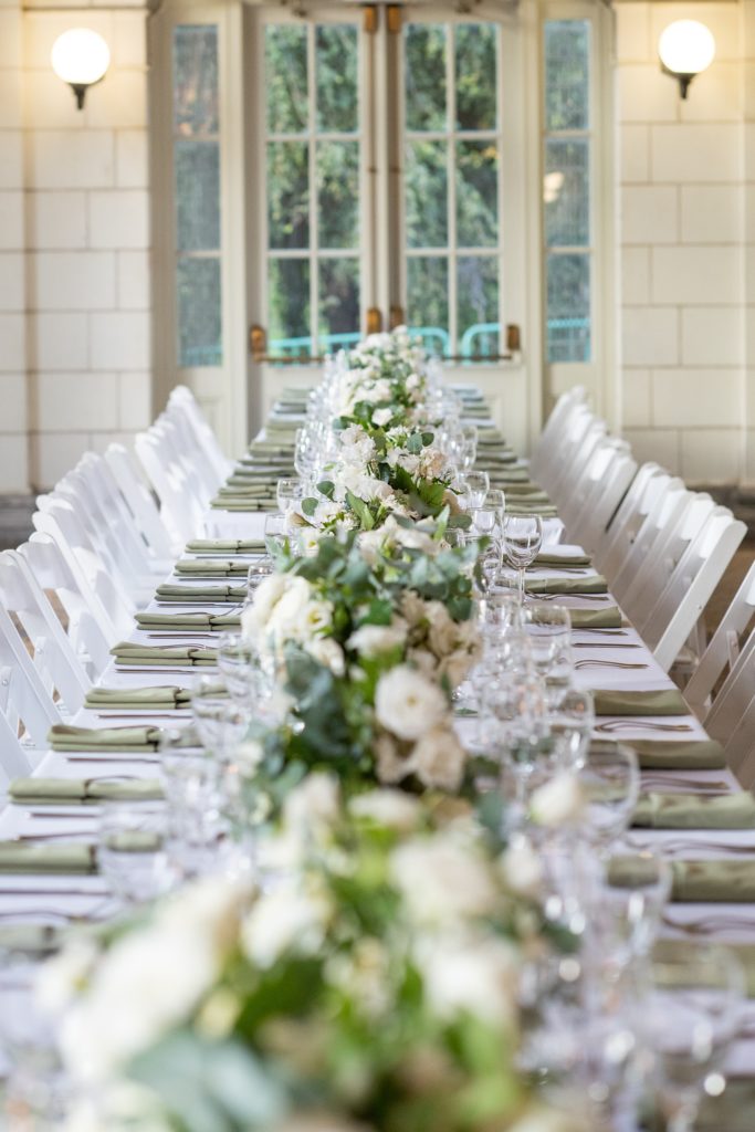 Prospect Park Boathouse wedding photos in Brooklyn, New York by Mikkel Paige Photography. This city wedding venue joins the indoors with the outdoors in a park setting with a historic New York City building. Photos include gay wedding decor inspiration and details with white flowers including dahlias, ranunculus, Veronica and Jasmine for a green and white palette. #mikkelpaige #prospectparkboathouse #brooklynwedding #brooklynweddingphotographer #whiteflowers #greenandwhitewedding #greenwedding