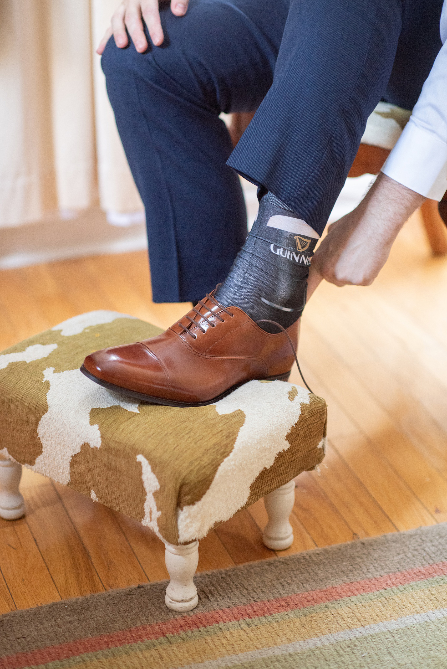 Getting ready wedding photos at Crabtree's Kittle House in Chappaqua, New York by Mikkel Paige Photography. This venue in Westchester county was the perfect place to capture the groom getting ready in a country setting, with his custom navy blue suit and Guinness socks! Click through for more fall wedding inspiration from their day! #bluesuit #mikkelpaige #CrabtreesKittleHouse #WestchesterWeddingVenues #WestchesterWedding #SeptemberWedding #gettingready #guinness #navysuits #customsuit #groom