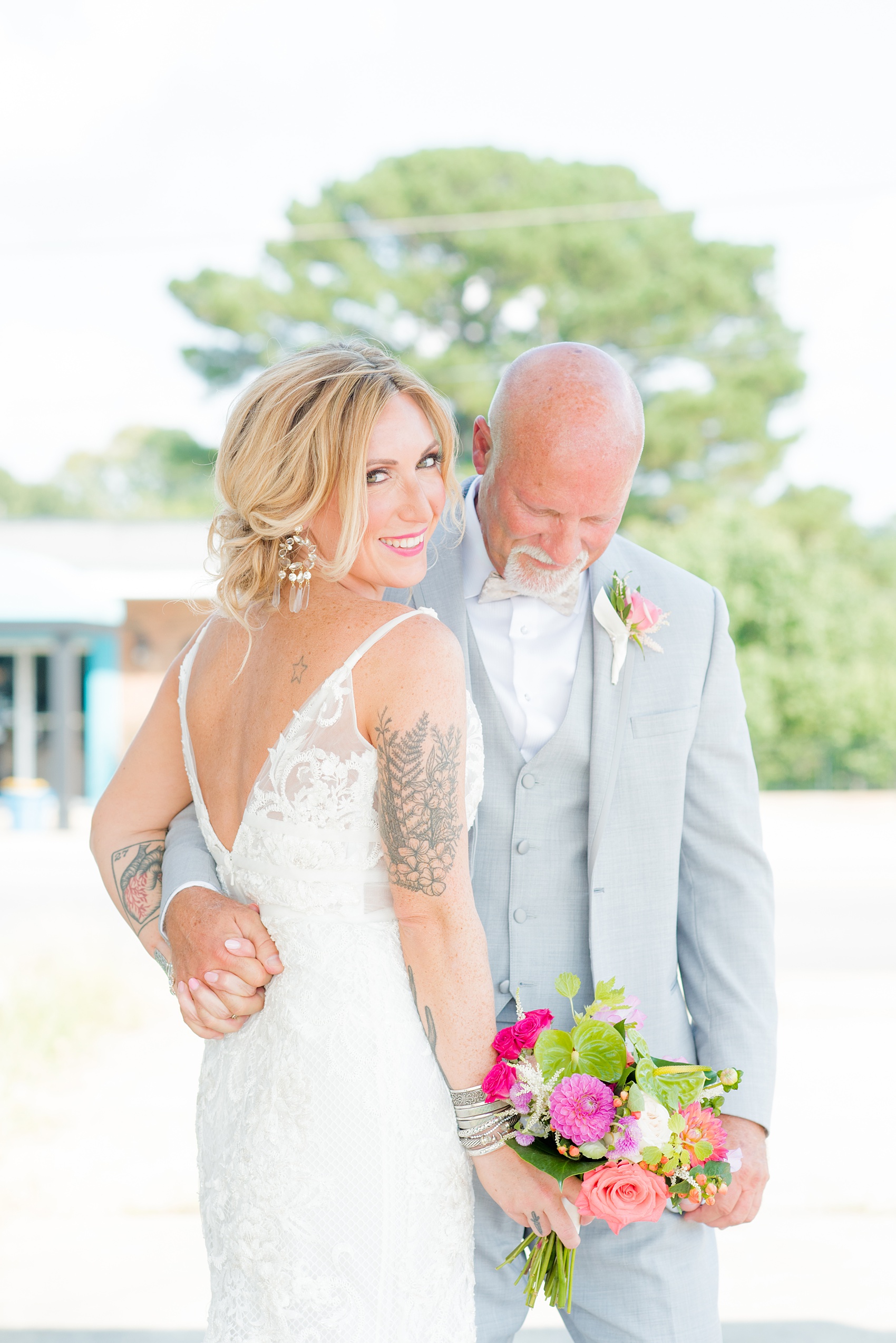 Highgrove Estate wedding photos in North Carolina by Mikkel Paige Photography. This tattooed bride + her groom wanted rustic, urban pictures in downtown Fuquay-Varina, near Raleigh. They had a pink + green palette, planned by @asouthernsoiree, with tropical flowers and balloons for their tented dinner. Click through for all the details for their awesome party! #NorthCarolinaVenues #WeddingVenues #MikkelPaige #ASouthernSoiree #tropicalflowers #brideandgroom #tattooedbride #weddingdetails