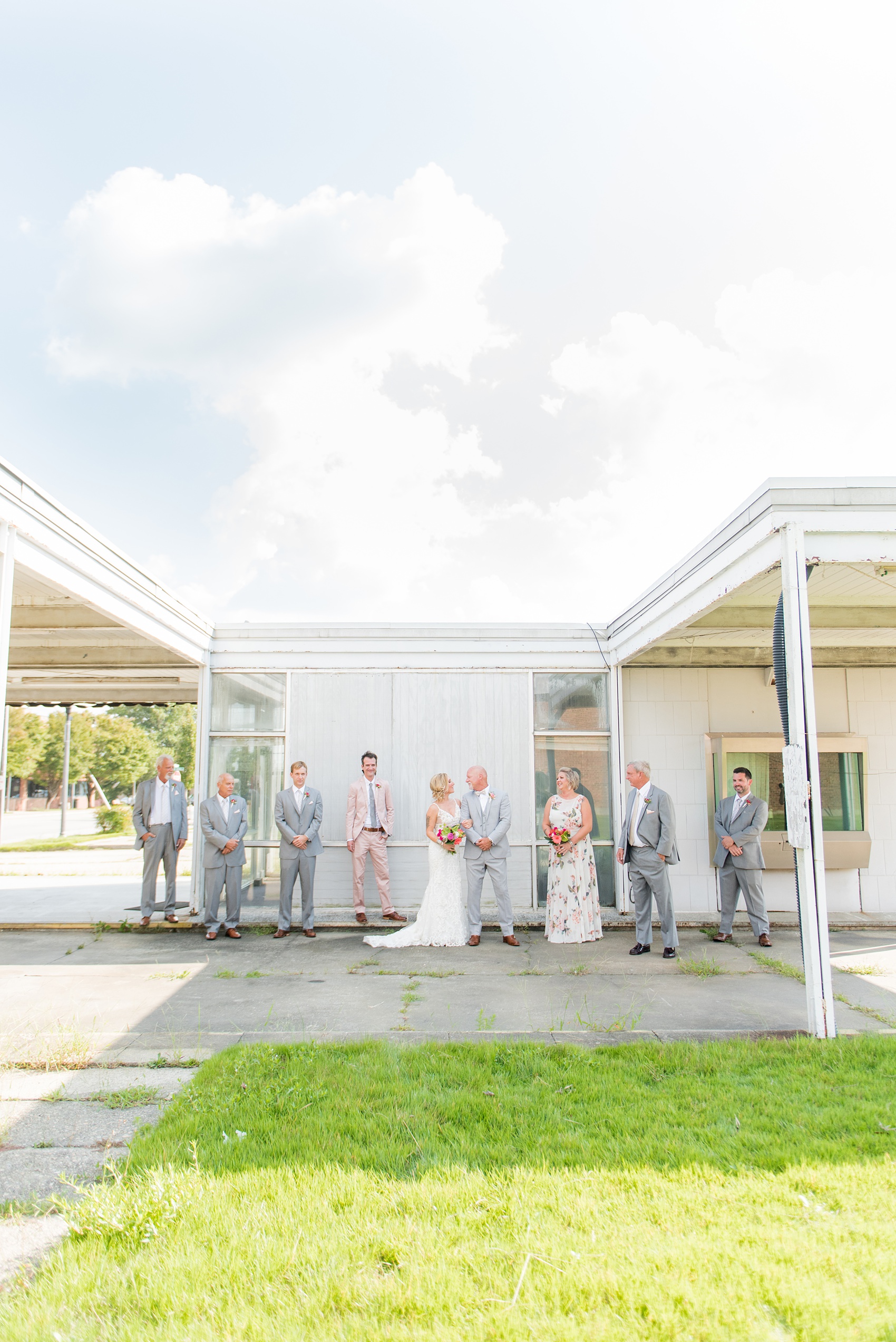 Highgrove Estate wedding photos in North Carolina by Mikkel Paige Photography. The bride + groom wanted urban, rustic pictures outdoors in downtown Fuquay-Varina with their wedding party, near Raleigh. They had a pink + green palette, planned by @asouthernsoiree, with tropical flowers for their tented dinner. The groomsmen wore grey + pink, and maid of honor a floral pattern dress. Click for pictures from their awesome party! #NorthCarolinaVenues #MikkelPaige #ASouthernSoiree #weddingparty