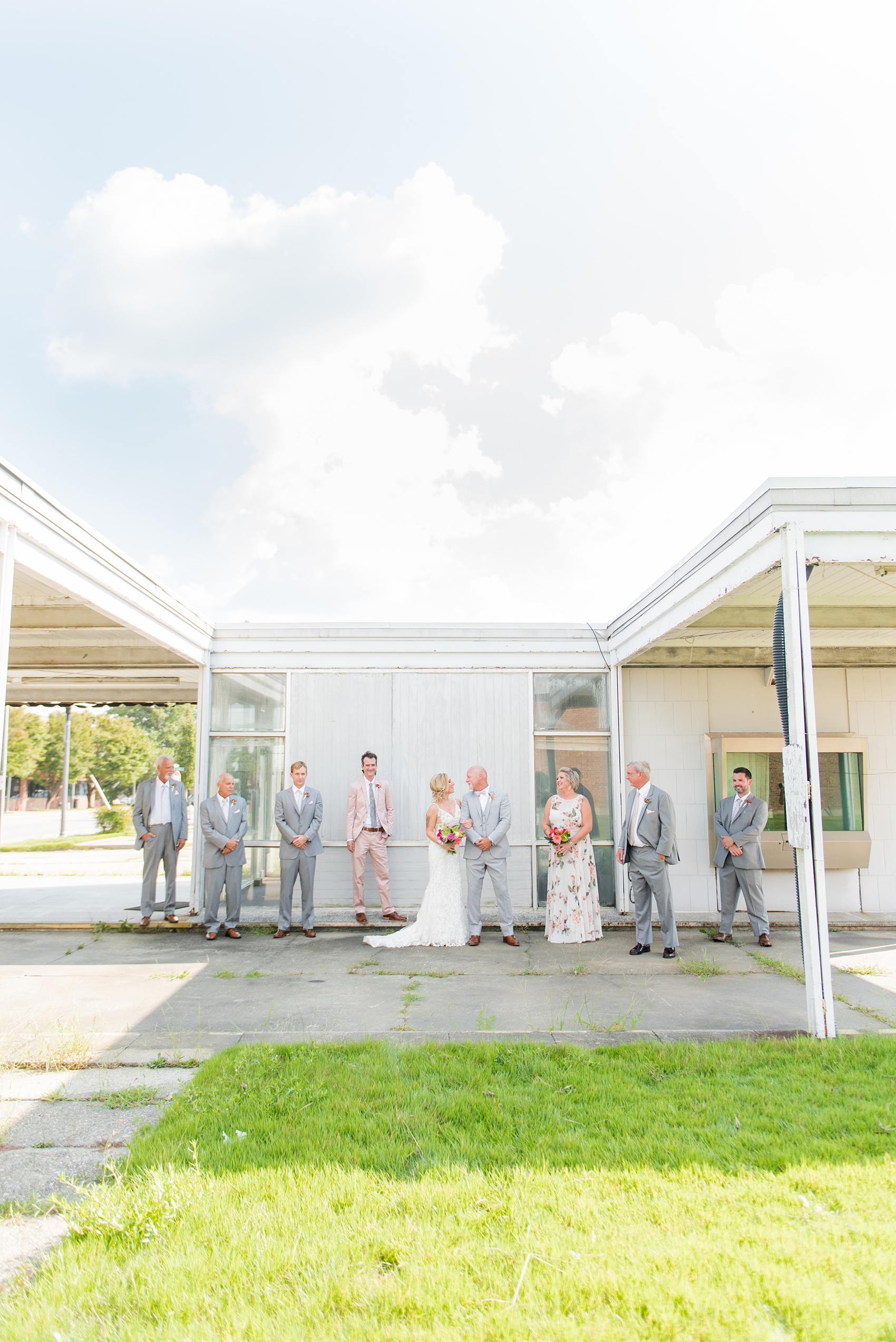 Highgrove Estate wedding photos in North Carolina by Mikkel Paige Photography. The bride + groom wanted urban, rustic pictures outdoors in downtown Fuquay-Varina with their wedding party, near Raleigh. They had a pink + green palette, planned by @asouthernsoiree, with tropical flowers for their tented dinner. The groomsmen wore grey + pink, and maid of honor a floral pattern dress. Click for pictures from their awesome party! #NorthCarolinaVenues #MikkelPaige #ASouthernSoiree #weddingparty