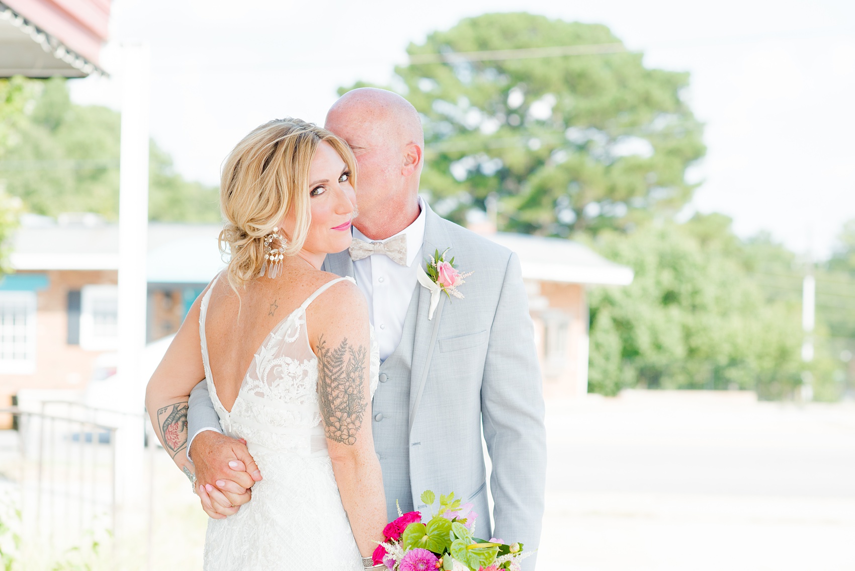 Highgrove Estate wedding photos in North Carolina by Mikkel Paige Photography. This tattooed bride + her groom groom wanted rustic, urban pictures in downtown Fuquay-Varina, near Raleigh. They had a pink + green palette, planned by @asouthernsoiree, with tropical flowers and balloons for their tented dinner. Click through for all the details for their awesome party! #NorthCarolinaVenues #WeddingVenues #MikkelPaige #ASouthernSoiree #tropicalflowers #brideandgroom #tattooedbride #weddingdetails
