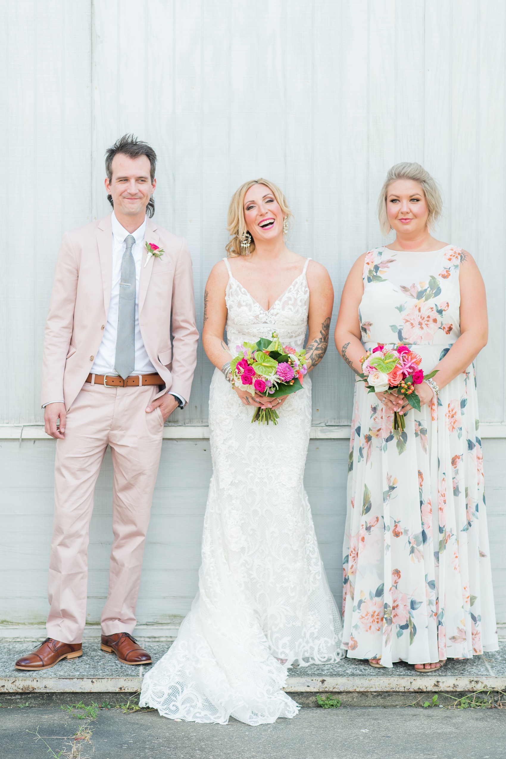 Highgrove Estate wedding photos in North Carolina by Mikkel Paige Photography. The bride + groom wanted urban, rustic pictures outdoors in downtown Fuquay-Varina with their wedding party, near Raleigh. They had a pink + green palette, planned by @asouthernsoiree, with tropical flowers for their tented dinner. The groomsmen wore grey + pink, and maid of honor a floral pattern dress. Click for pictures from their awesome party! #NorthCarolinaVenues #MikkelPaige #ASouthernSoiree #weddingparty