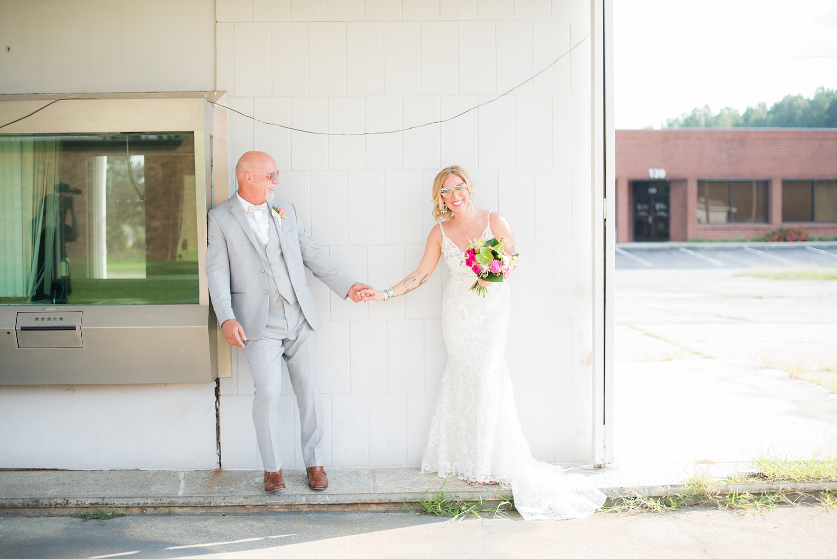 Highgrove Estate wedding photos in North Carolina by Mikkel Paige Photography. This tattooed bride + groom wanted playful, urban pictures in downtown Fuquay-Varina, near Raleigh. They had a pink + green palette, planned by @asouthernsoiree, with tropical flowers and balloons for their tented dinner. Click through for all the details for their awesome party! #NorthCarolinaVenues #WeddingVenues #MikkelPaige #ASouthernSoiree #tropicalflowers #brideandgroom #tattooedbride #weddingdetails