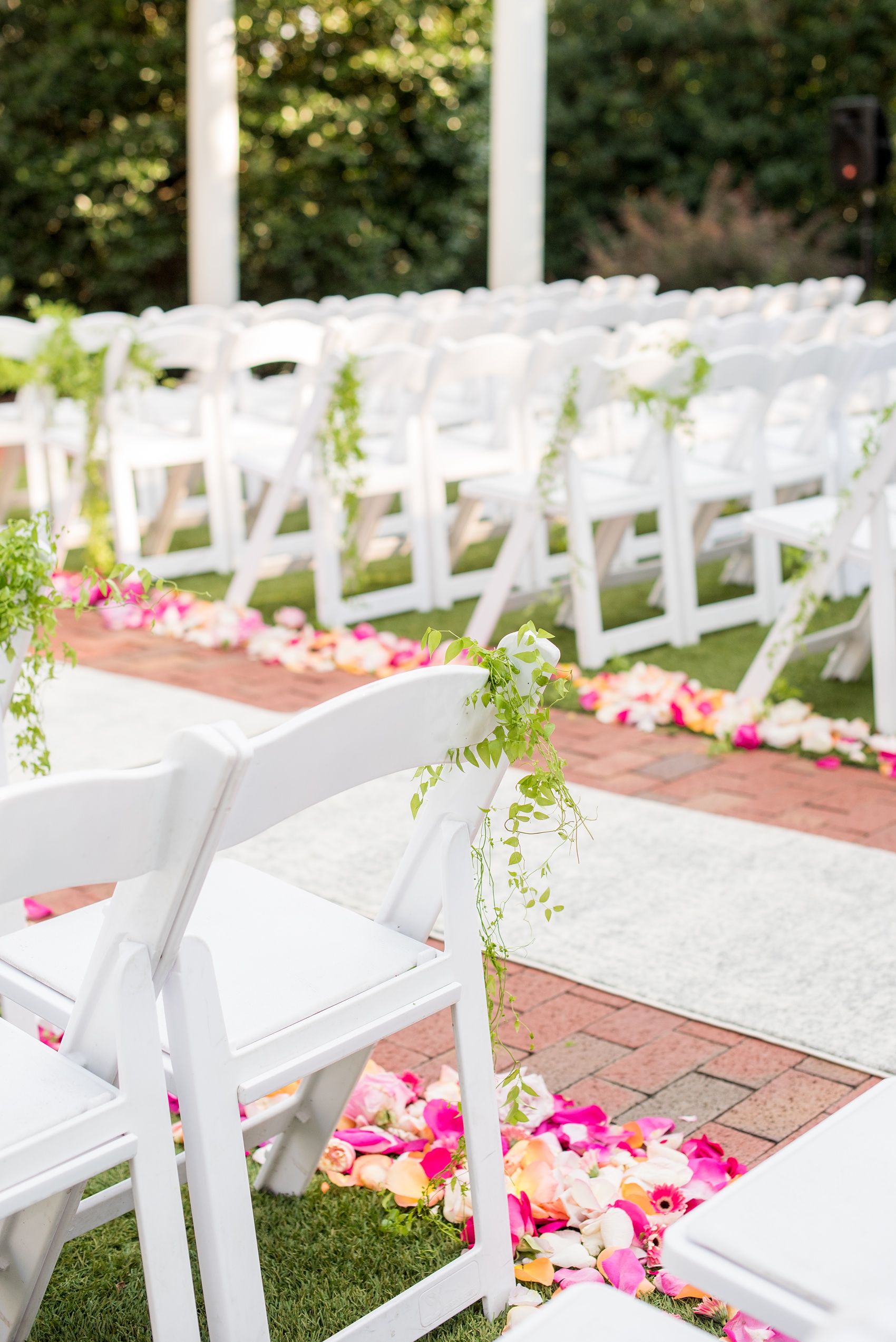 Highgrove Estate wedding photos by Mikkel Paige Photography. It’s a beautiful venue for a wedding large or small, near Raleigh, North Carolina. This wedding had fun signs, custom stationery and table numbers that said places the bride & groom travel to, and romantic candlelight planned by @asouthernsoiree. Click through to see the tropical green leaves, pink and orange flowers dripping from their outdoor ceremony space! #NorthCarolinaVenues #MikkelPaige #ASouthernSoiree #OutdoorCeremony