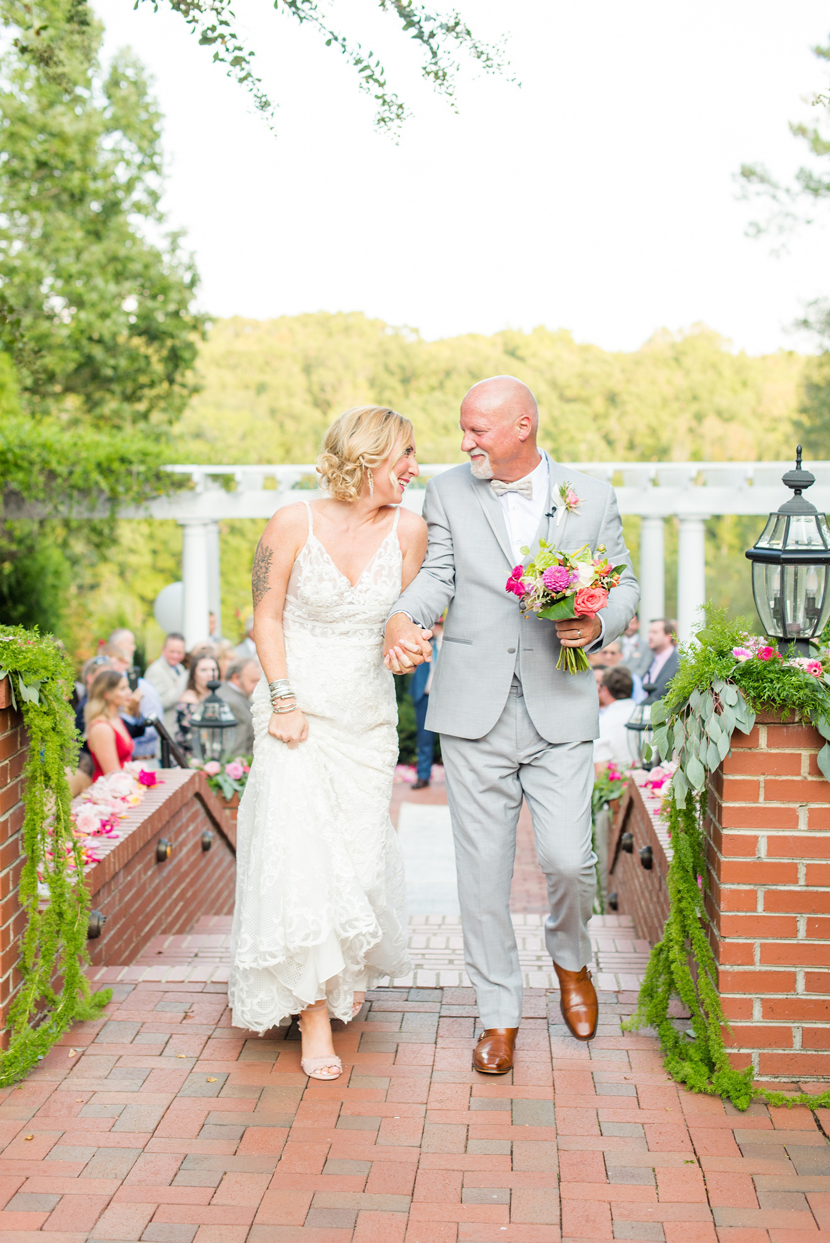 Highgrove Estate wedding photos by Mikkel Paige Photography. It’s a beautiful venue for a wedding large or small, near Raleigh, North Carolina. This wedding had fun signs, custom stationery and table numbers that said places the bride & groom travel to, and romantic candlelight planned by @asouthernsoiree. Click through to see the tropical green leaves, pink and orange flowers dripping from their outdoor ceremony space! #NorthCarolinaVenues #MikkelPaige #ASouthernSoiree #OutdoorCeremony