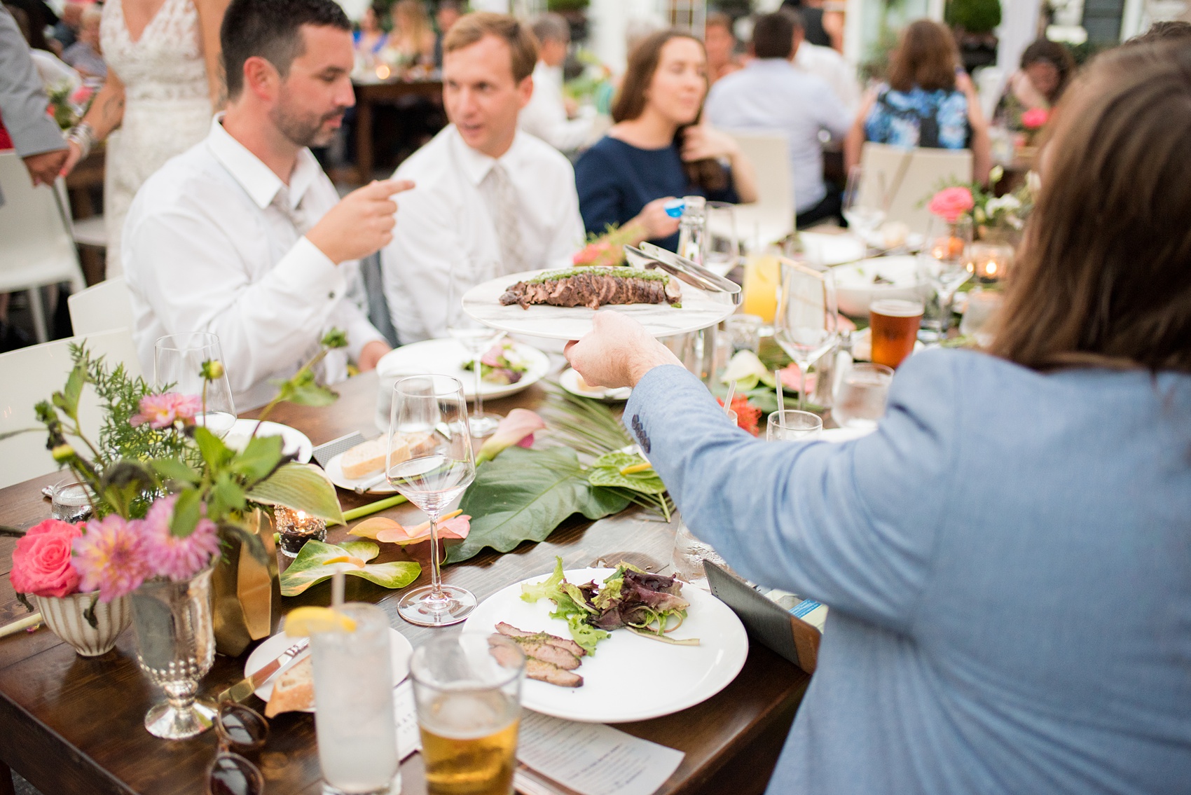 Highgrove Estate wedding photos by Mikkel Paige Photography. This beautiful venue works for a wedding large or small, near Raleigh, North Carolina. Their in-house catering is awesome: just look at this family style wedding reception with steak and fresh salad with watermelon radishes. The romantic celebration was planned by @asouthernsoiree. Click through to more from their tented, balloon-filled reception space! #MikkelPaige #ASouthernSoiree #familystyledinner #highgroveestate