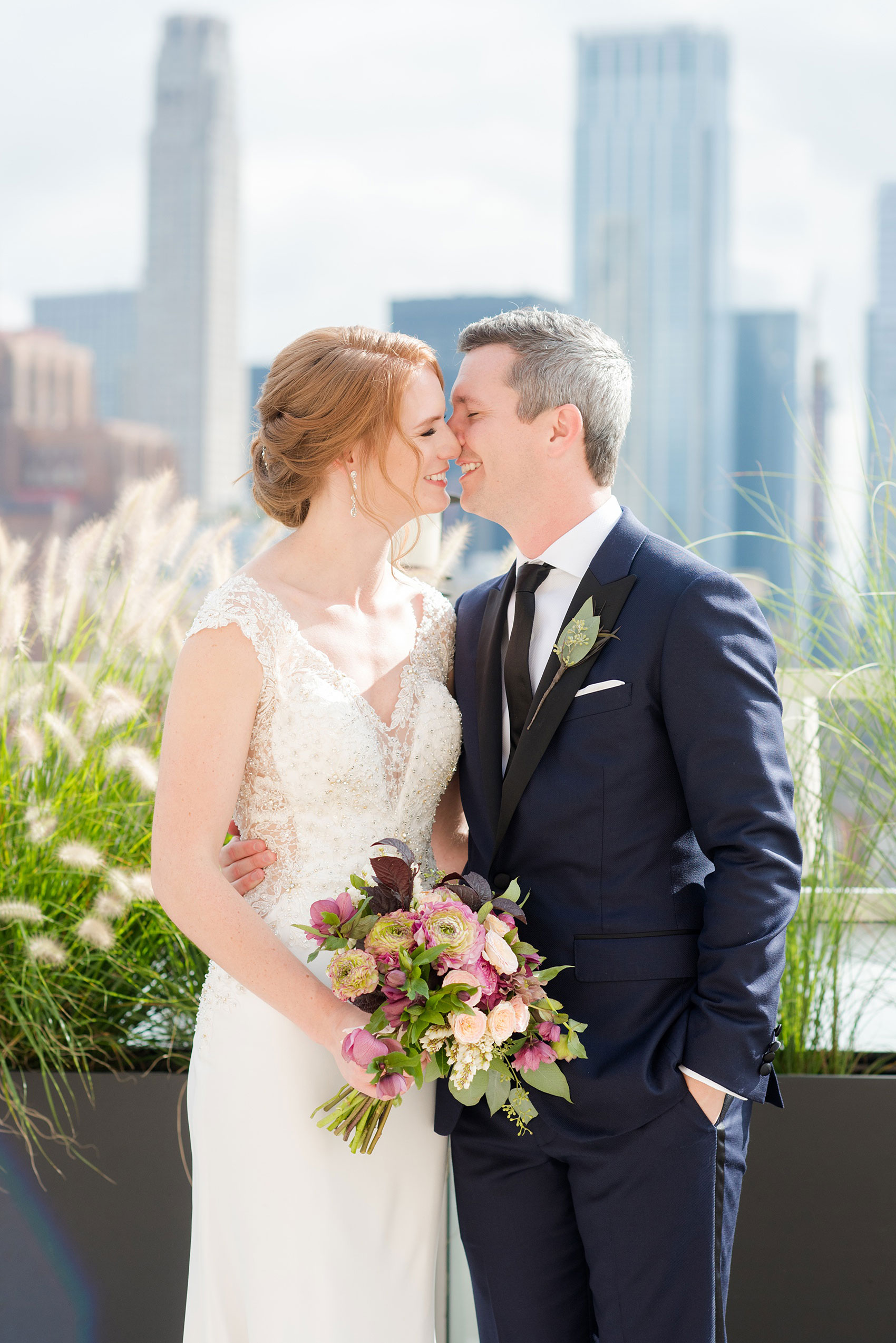 Photos of a NYC wedding venue, Tribeca Rooftop, by Mikkel Paige Photography. This ceremony and reception location has an outdoor space overlooking the Manhattan skyline. These pictures of the bride and groom will provide inspiration in New York! She wore a lace illusion gown with beading, her hair up, and carried a bouquet of fall flowers and he was in a navy suit. Click through for more details from this celebration! #TribecaRooftop #MikkelPaige #NYCwedding #NYCWeddingVenues #BrideandGroom 