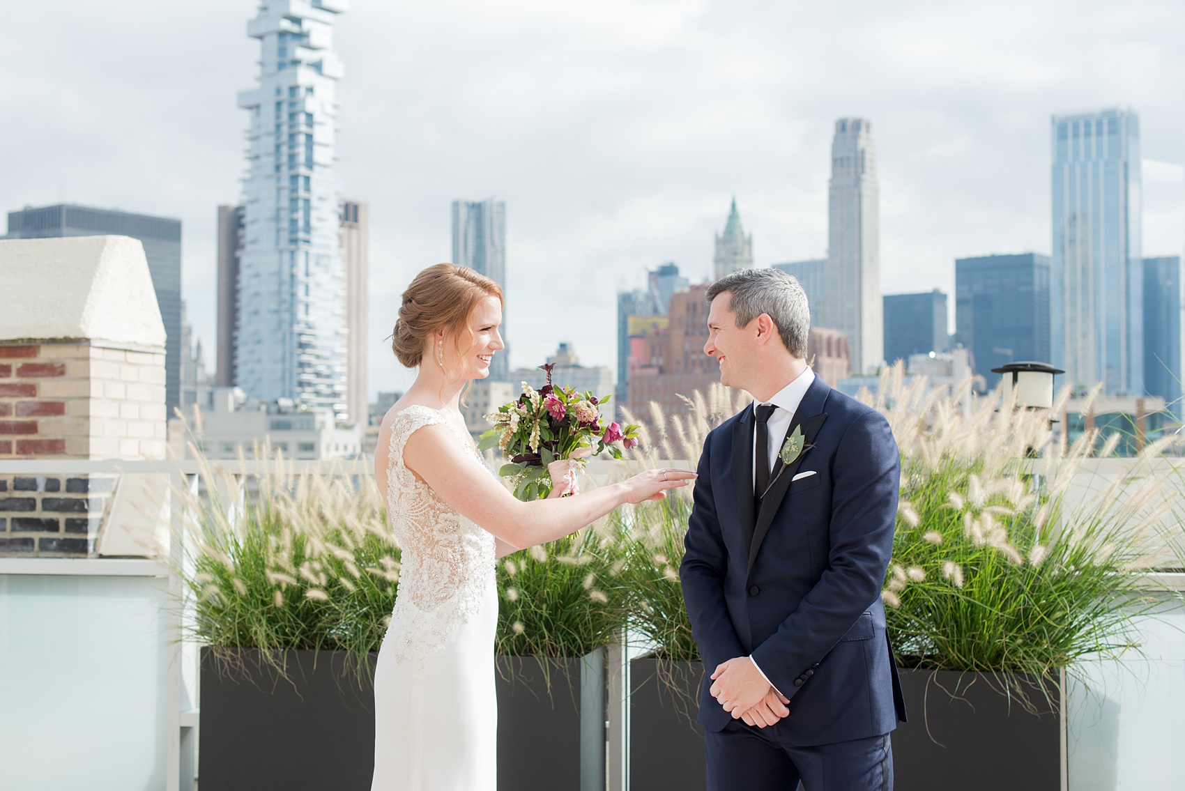 Photos of a NYC wedding venue, Tribeca Rooftop, by Mikkel Paige Photography. This ceremony and reception location has an outdoor space overlooking the Manhattan skyline. These pictures of the bride and groom will provide inspiration in New York! She wore a lace illusion gown with beading, her hair up, and carried a bouquet of fall flowers and he was in a navy suit. Click through for more details from this celebration! #TribecaRooftop #MikkelPaige #NYCwedding #NYCWeddingVenues #BrideandGroom 