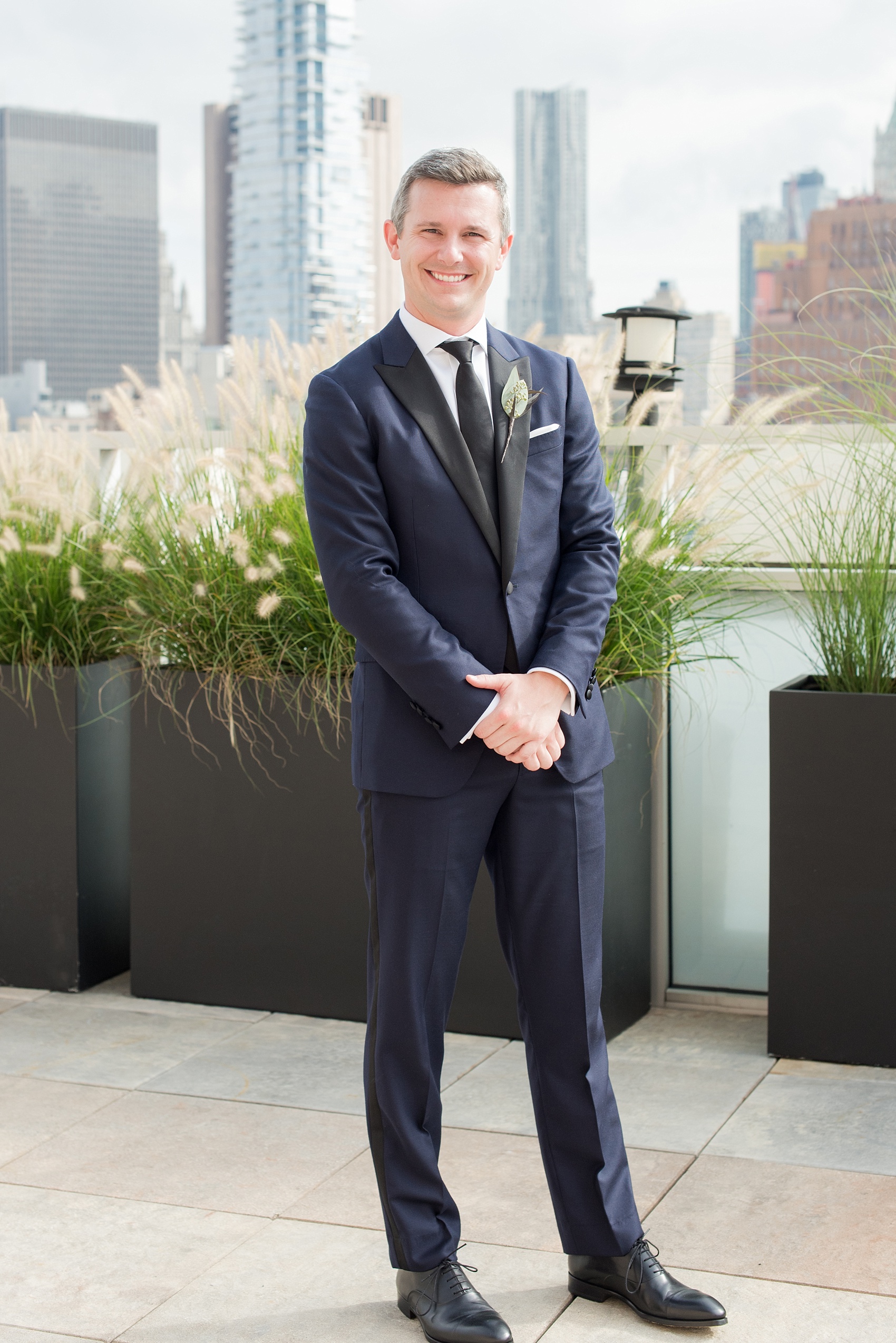 Photos of a NYC wedding venue, Tribeca Rooftop, by Mikkel Paige Photography. This ceremony and reception location has an outdoor space overlooking the Manhattan skyline. These pictures will provide inspiration in New York! The groom wore a simple leaf boutonniere on his navy suit. Click through for more details from this celebration! #TribecaRooftop #MikkelPaige #NYCwedding #NYCWeddingVenues #NYCWeddingPhotography #leafboutonniere #fallflowers