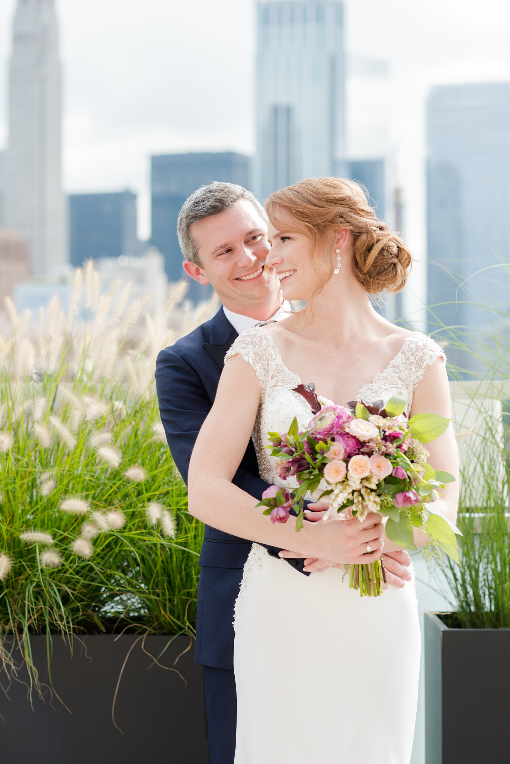 Photos of a NYC wedding venue, Tribeca Rooftop, by Mikkel Paige Photography. This ceremony and reception location has an outdoor space overlooking the Manhattan skyline. These pictures of the bride and groom will provide inspiration in New York! She wore a lace illusion gown with beading, her hair up, and carried a bouquet of fall flowers and he was in a navy suit. Click through for more details from this celebration! #TribecaRooftop #MikkelPaige #NYCwedding #NYCWeddingVenues #BrideandGroom 