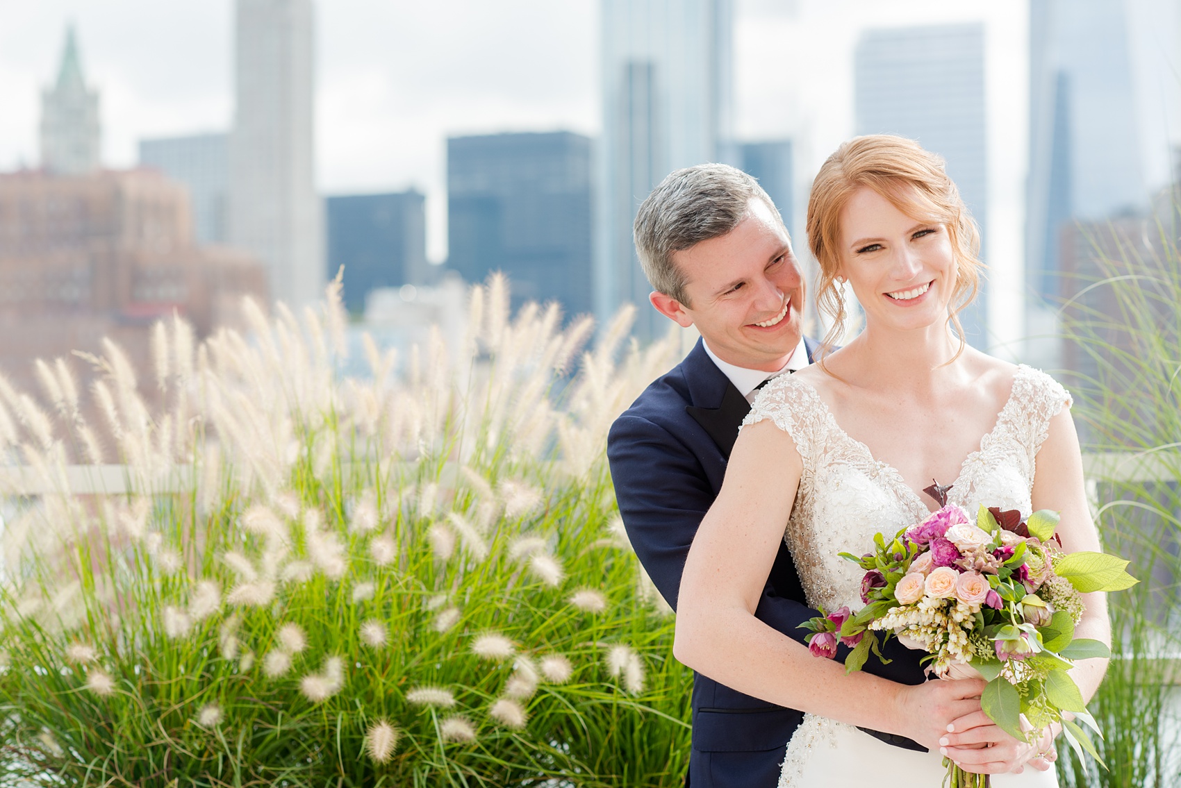 Photos of a NYC wedding venue, Tribeca Rooftop, by Mikkel Paige Photography. This ceremony and reception location has an outdoor space overlooking the Manhattan skyline. These pictures of the bride and groom will provide inspiration in New York! She wore a lace illusion gown with beading, her hair up, and carried a bouquet of fall flowers and he was in a navy suit. Click through for more details from this celebration! #TribecaRooftop #MikkelPaige #NYCwedding #NYCWeddingVenues #BrideandGroom 