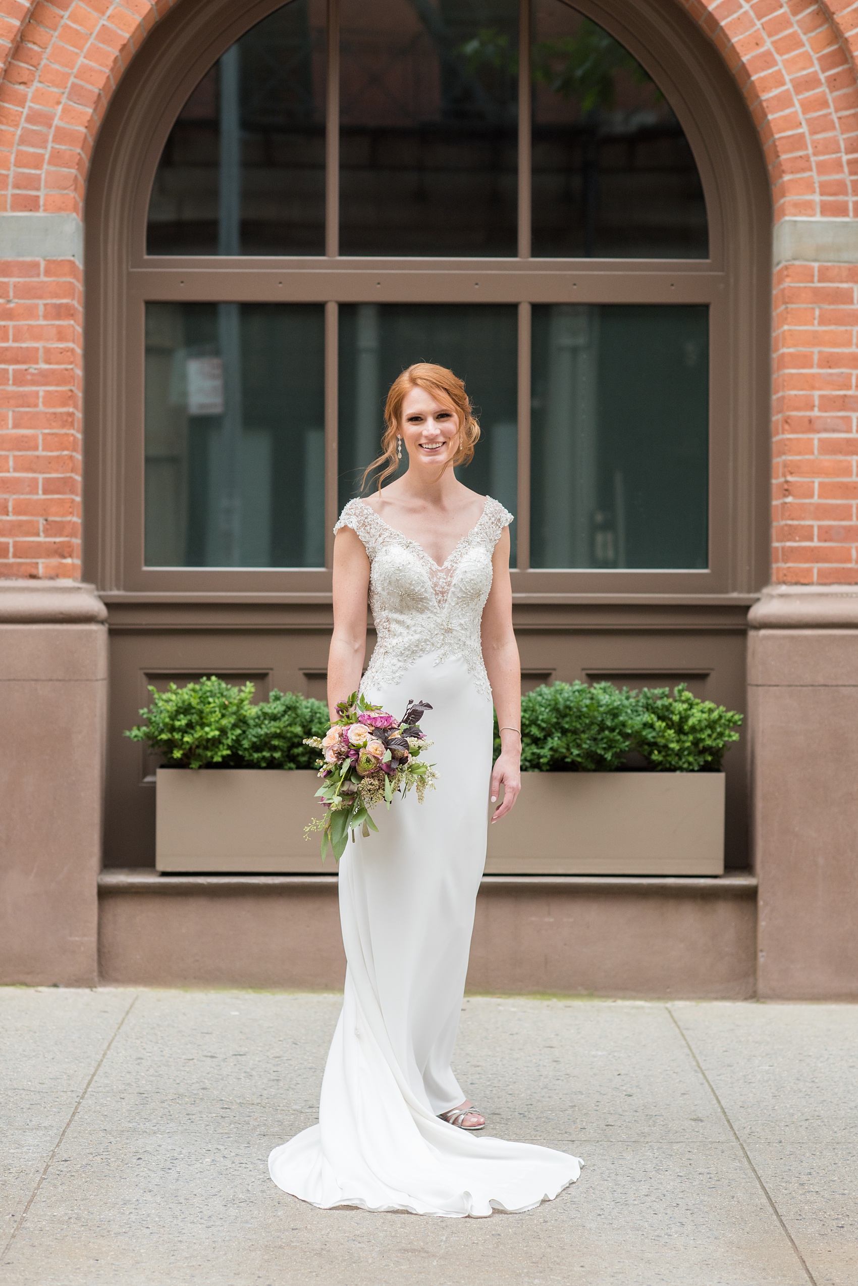 Photos of a NYC wedding venue, Tribeca Rooftop, by Mikkel Paige Photography. This ceremony and reception location has an outdoor space overlooking the Manhattan skyline. These pictures will provide inspiration in New York! The bride wore a lace illusion gown with beading, her hair up, and carried a bouquet of fall flowers. Click through for more details from this celebration! #TribecaRooftop #MikkelPaige #NYCwedding #NYCWeddingVenues #NYCWeddingPhotography #Ranunculus #FallBouquet 