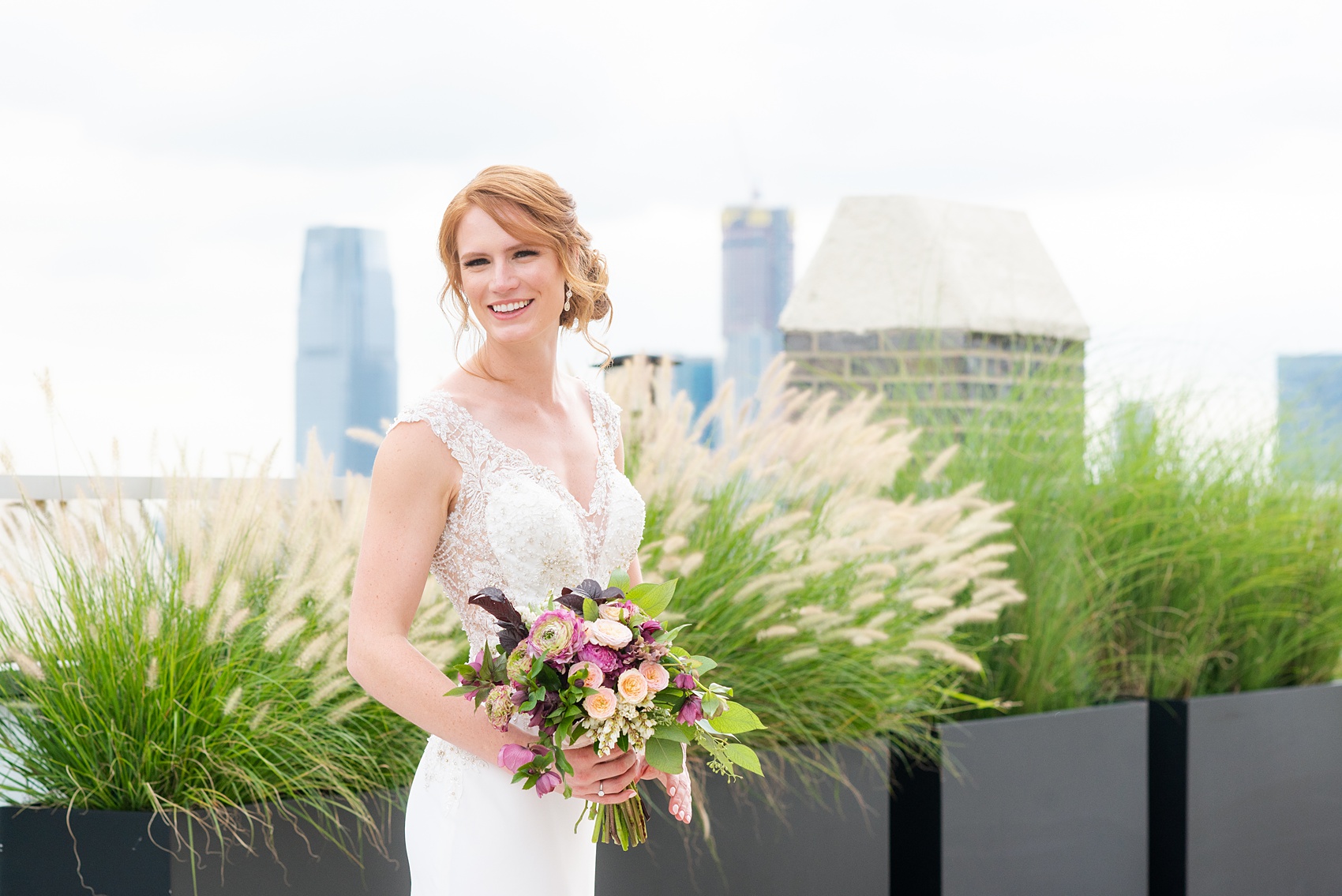 Photos of a NYC wedding venue, Tribeca Rooftop, by Mikkel Paige Photography. This ceremony and reception location has an outdoor space overlooking the Manhattan skyline. These pictures will provide inspiration in New York! The bride wore a lace illusion gown with beading, her hair up, and carried a bouquet of fall flowers. Click through for more details from this celebration! #TribecaRooftop #MikkelPaige #NYCwedding #NYCWeddingVenues #NYCWeddingPhotography #Ranunculus #FallBouquet 