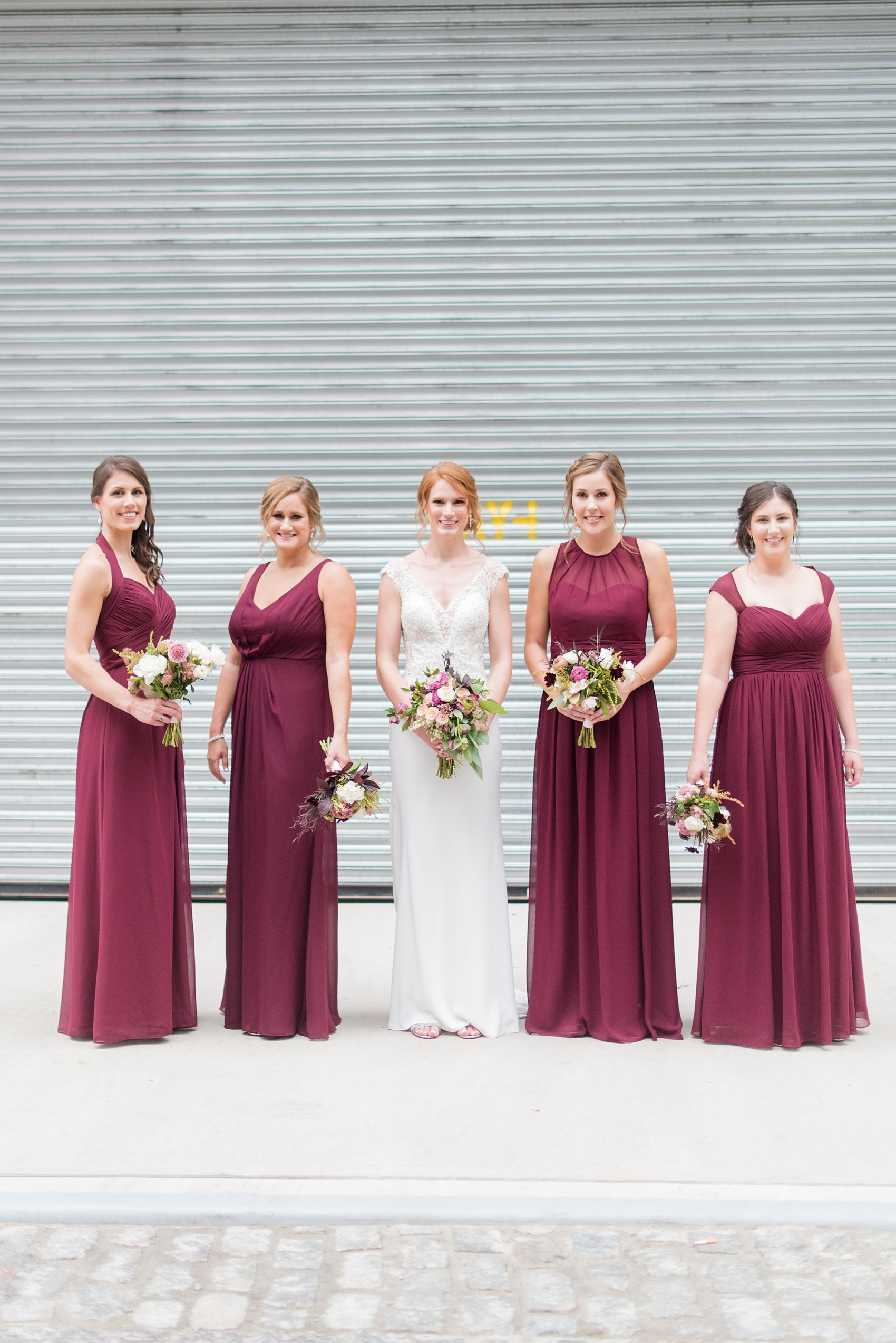 Photos of a NYC wedding venue, Tribeca Rooftop, by Mikkel Paige Photography. This ceremony and reception location has an outdoor space overlooking the Manhattan skyline. These pictures will provide inspiration in New York! The bride was surrounded by her bridesmaids in cranberry gowns, holding fall flowers. Click through for more details from this celebration! #TribecaRooftop #MikkelPaige #NYCwedding #NYCWeddingVenues #NYCWeddingPhotography #CranberryBridesmaids #FallBouquet