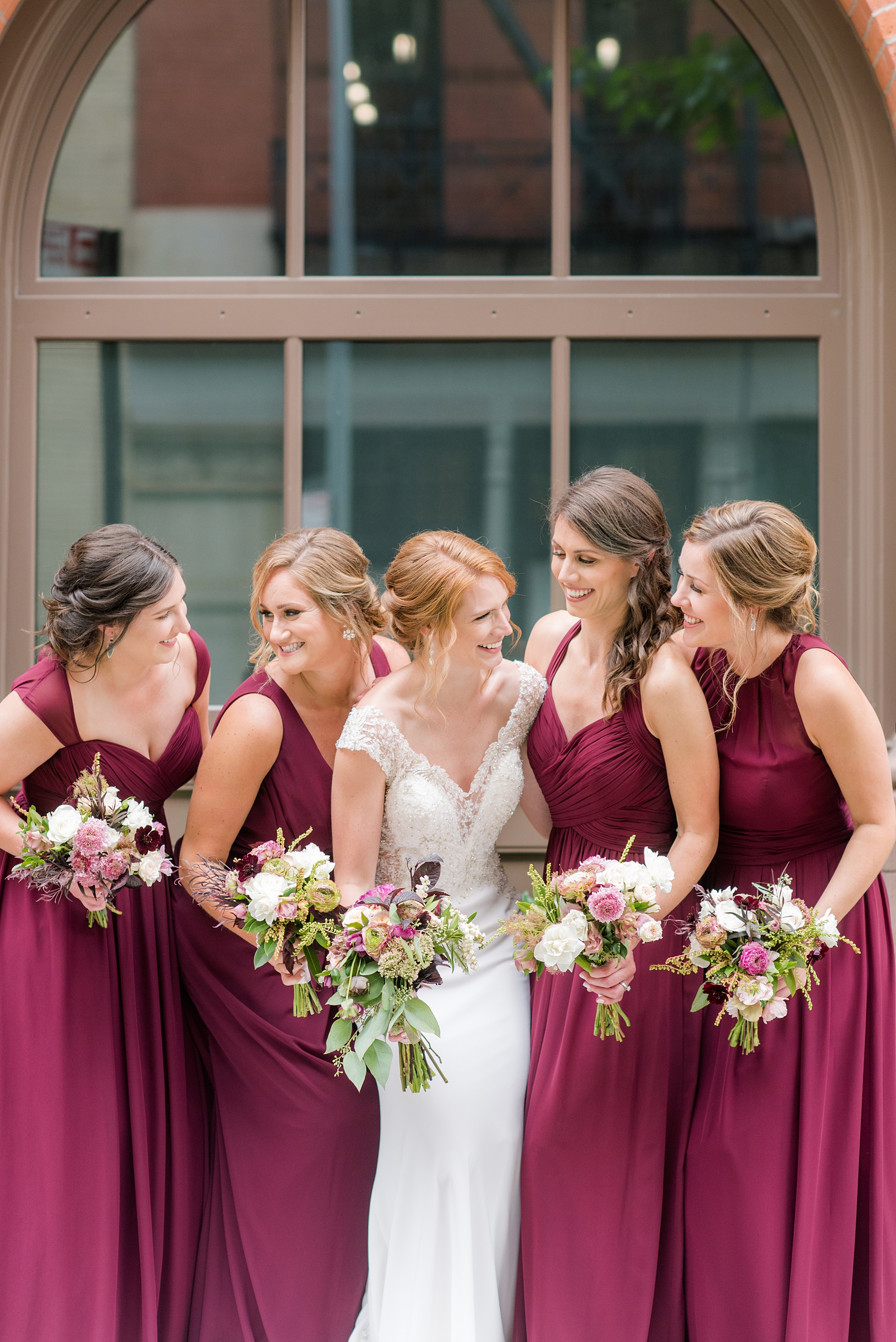 Photos of a NYC wedding venue, Tribeca Rooftop, by Mikkel Paige Photography. This ceremony and reception location has an outdoor space overlooking the Manhattan skyline. These pictures will provide inspiration in New York! The bride was surrounded by her bridesmaids in cranberry gowns, holding fall flowers. Click through for more details from this celebration! #TribecaRooftop #MikkelPaige #NYCwedding #NYCWeddingVenues #NYCWeddingPhotography #CranberryBridesmaids #FallBouquet