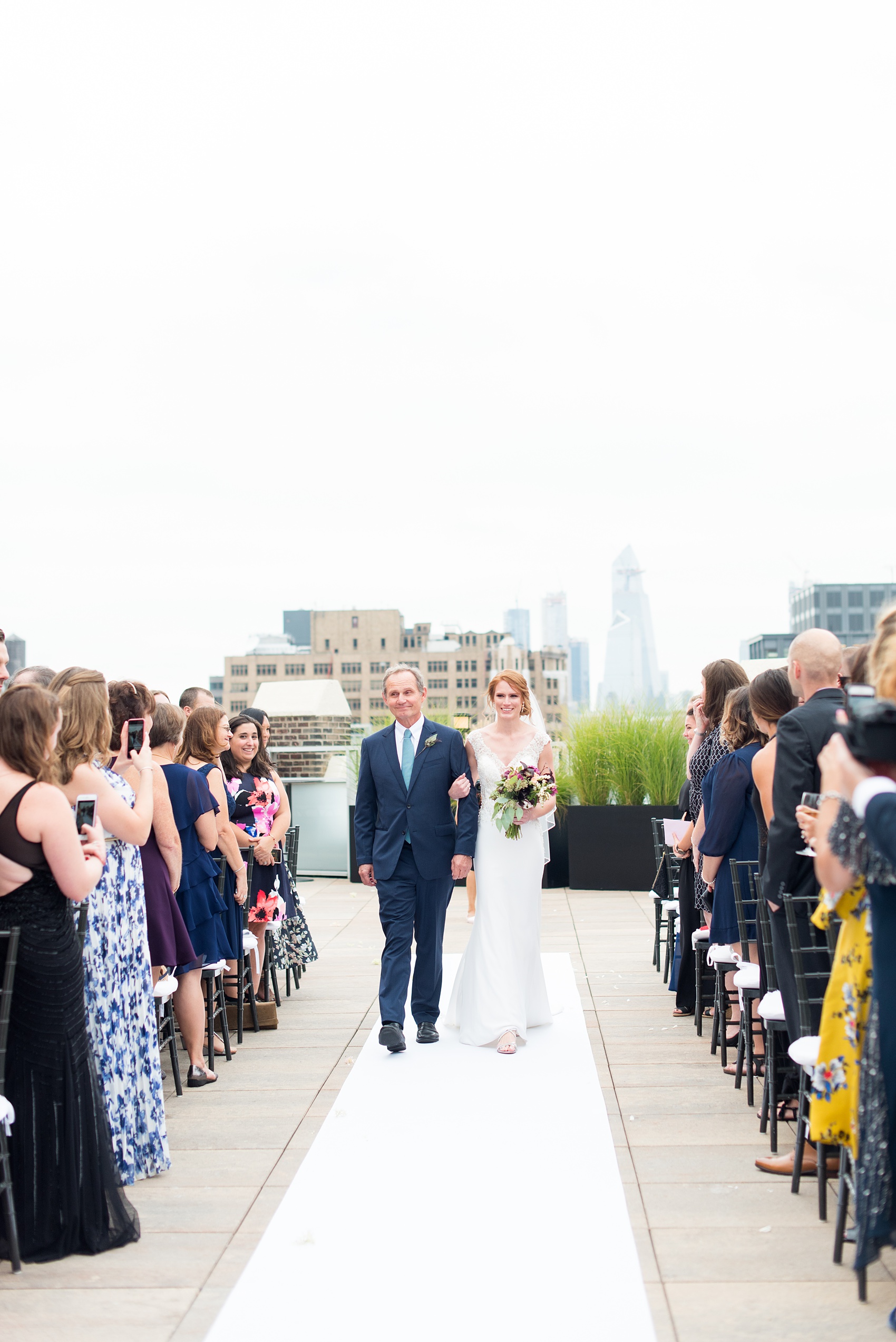 Photos of a NYC wedding venue, Tribeca Rooftop, by Mikkel Paige Photography. This ceremony and reception location has an outdoor space overlooking the Manhattan skyline. These pictures will provide inspiration in New York! The couple dreamed of getting married in this awesome city with flowers and colors of fall. Click through for more details from this beautiful celebration! #TribecaRooftop #NYCVenues #MikkelPaige #NYCwedding #NYCskyline #NYCWeddingPhotos #NYCWeddingPhotography