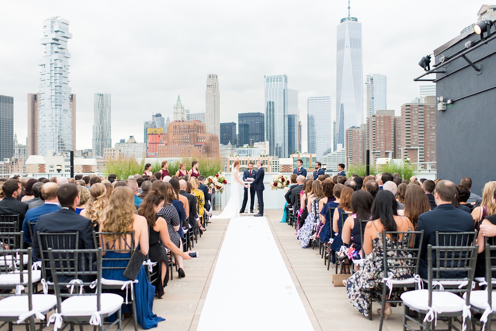 Photos of a NYC wedding venue, Tribeca Rooftop, by Mikkel Paige Photography. This ceremony and reception location has an outdoor space overlooking the Manhattan skyline. These pictures will provide inspiration in New York! The couple dreamed of getting married in this awesome city with flowers and colors of fall. Click through for more details from this beautiful celebration! #TribecaRooftop #NYCVenues #MikkelPaige #NYCwedding #NYCskyline #NYCWeddingPhotos #NYCWeddingPhotography