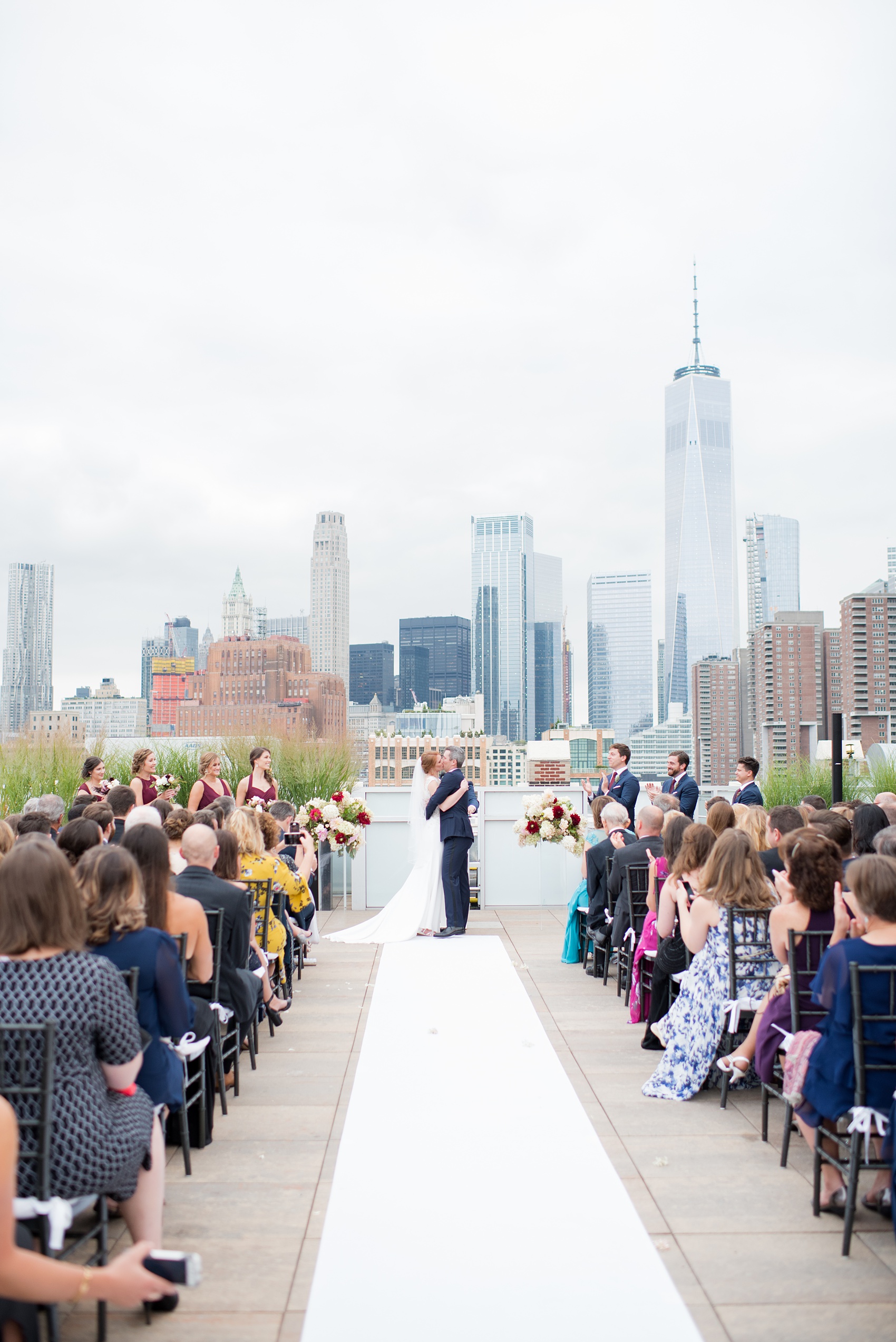 Photos of a NYC wedding venue, Tribeca Rooftop, by Mikkel Paige Photography. This ceremony and reception location has an outdoor space overlooking the Manhattan skyline. These pictures will provide inspiration in New York! The couple dreamed of getting married in this awesome city with flowers and colors of fall. Click through for more details from this beautiful celebration! #TribecaRooftop #NYCVenues #MikkelPaige #NYCwedding #NYCskyline #NYCWeddingPhotos #NYCWeddingPhotography
