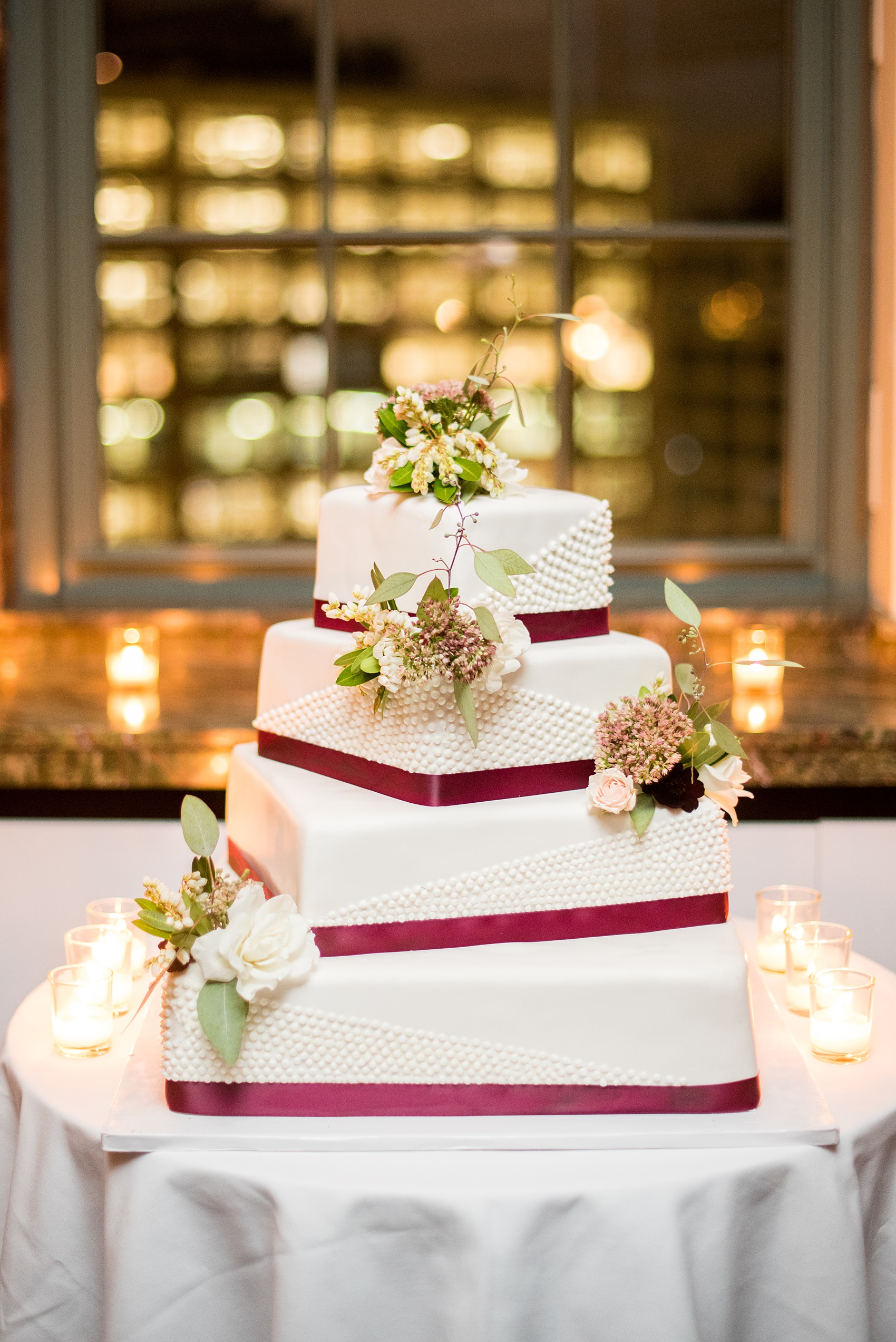 Photos of a NYC wedding venue, Tribeca Rooftop, by Mikkel Paige Photography. This ceremony and reception location has an outdoor space overlooking the Manhattan skyline. These pictures will provide inspiration in New York! The couple dreamed of getting married in this awesome city with flowers and colors of fall. Click through for more details from this beautiful celebration! #TribecaRooftop #NYCVenues #MikkelPaige #NYCwedding #NYCskyline #NYCWeddingPhotos #squareweddingcake