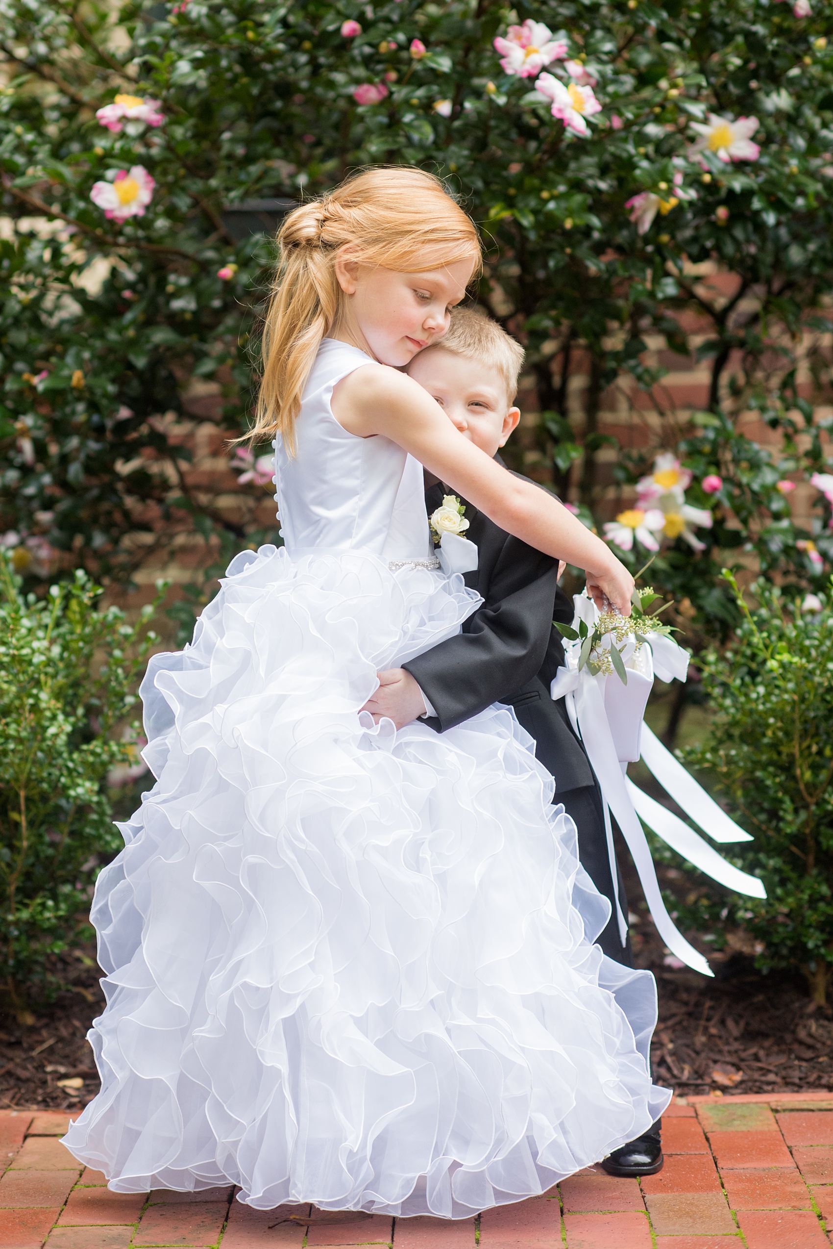 Photos of a fall wedding at The Carolina Inn, in Chapel Hill North Carolina, by Mikkel Paige Photography. This event venue doubles as a hotel for guests, who can enjoy a reception indoors or outdoors. This is the cutest photos of the flower girl and ring bearer, brother and sister, hugging! Click through to see inspiration from the entire wedding! Planner: @asouthernsoiree #thecarolinainn #ChapelHillWeddings #MikkelPaige #ASouthernSoiree #flowergirl #ringbearer