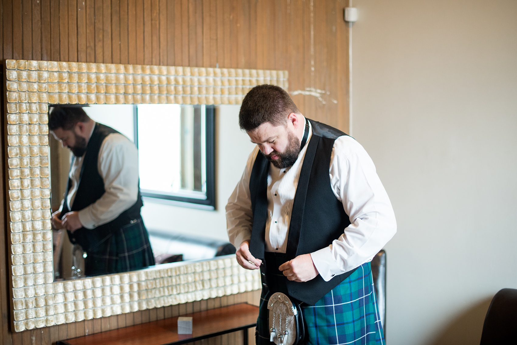 Mikkel Paige Photography captures beautiful groom portraits and his blue + green tartan, Scottish kilt, during his getting ready time before his wedding in Downtown Raleigh, North Carolina. Couple portraits were taken outdoors and the fun event continued inside the unique, historic venue. Click through for all the details from this unique celebration! #MikkelPaige #RaleighWeddingPhotographer #RaleighWeddingVenue #DowntownRaleighWedding #Groom #Kilt #ScottishGroom