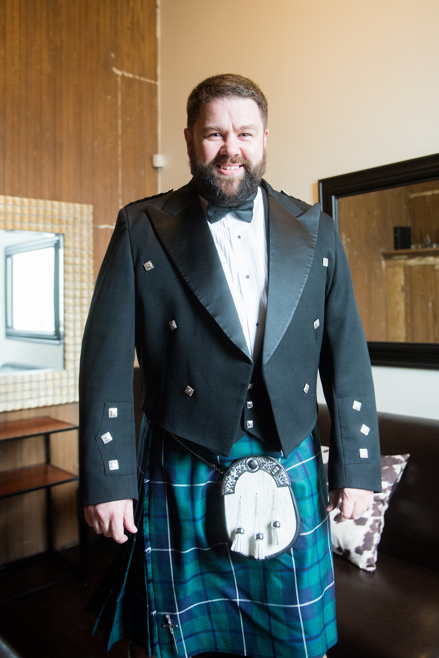 Mikkel Paige Photography captures beautiful groom portraits and his blue + green tartan, Scottish kilt, during his getting ready time before his wedding in Downtown Raleigh, North Carolina. Couple portraits were taken outdoors and the fun event continued inside the unique, historic venue. Click through for all the details from this unique celebration! #MikkelPaige #RaleighWeddingPhotographer #RaleighWeddingVenue #DowntownRaleighWedding #Groom #Kilt #ScottishGroom
