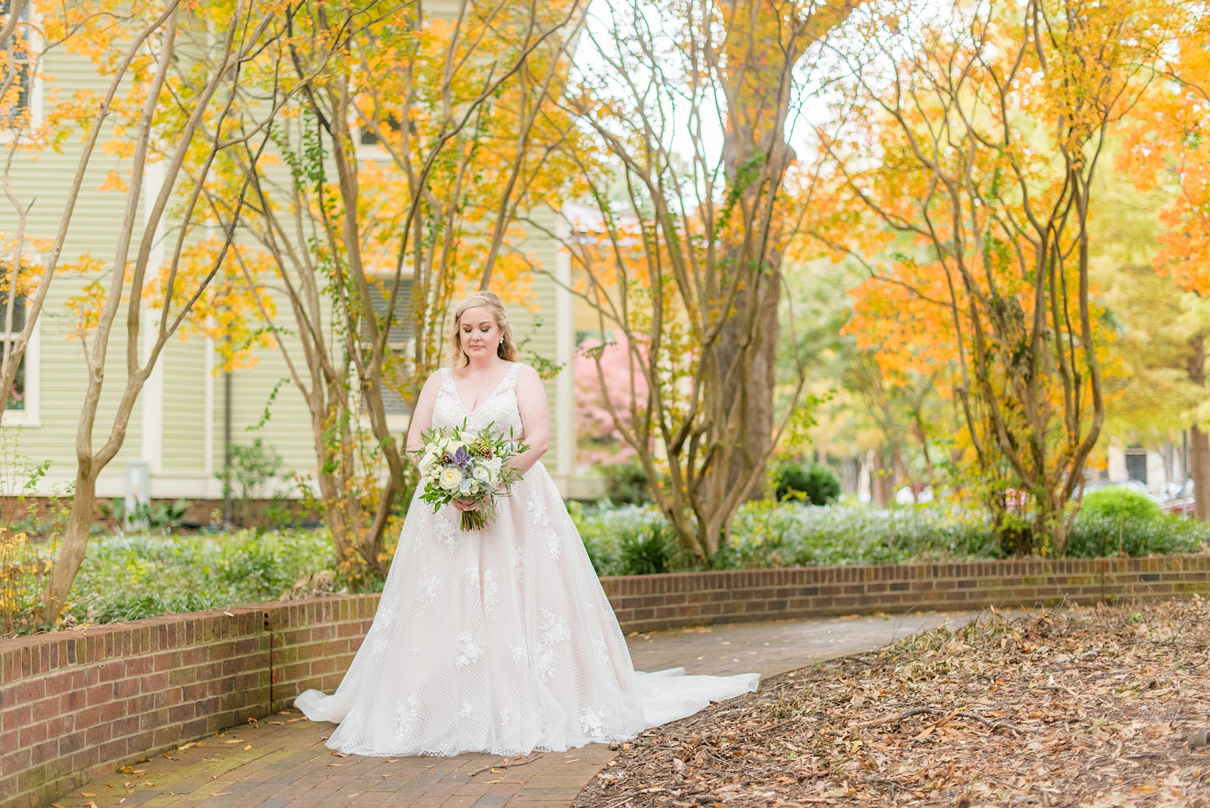 Mikkel Paige Photography captures a beautiful bridal portrait for a fall wedding in Downtown Raleigh, North Carolina. All Saints Chapel was their reception venue that they decorated with gold and silver decor and autumn centerpieces. Couple portraits were taken outdoors and the fun event continued inside the unique, and historic venue. Click through for all the details from this amazing celebration! #MikkelPaige #RaleighWeddingPhotographer #RaleighWeddingVenue #DowntownRaleighWedding