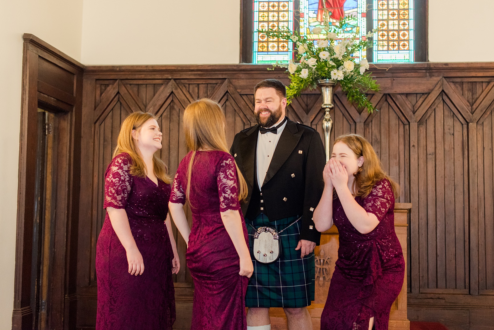 Mikkel Paige Photography captures a beautiful bride + groom during their fall wedding in Downtown Raleigh, North Carolina. All Saints Chapel was their ceremony + reception venue, which they decorated with gold + silver decor and autumn centerpieces. The groom was captured in a happy candid moment in this picture with his three daughters. Click through for all the details from this amazing celebration! #MikkelPaige #RaleighWeddingPhotographer #RaleighWeddingVenue #DowntownRaleighWedding #groom