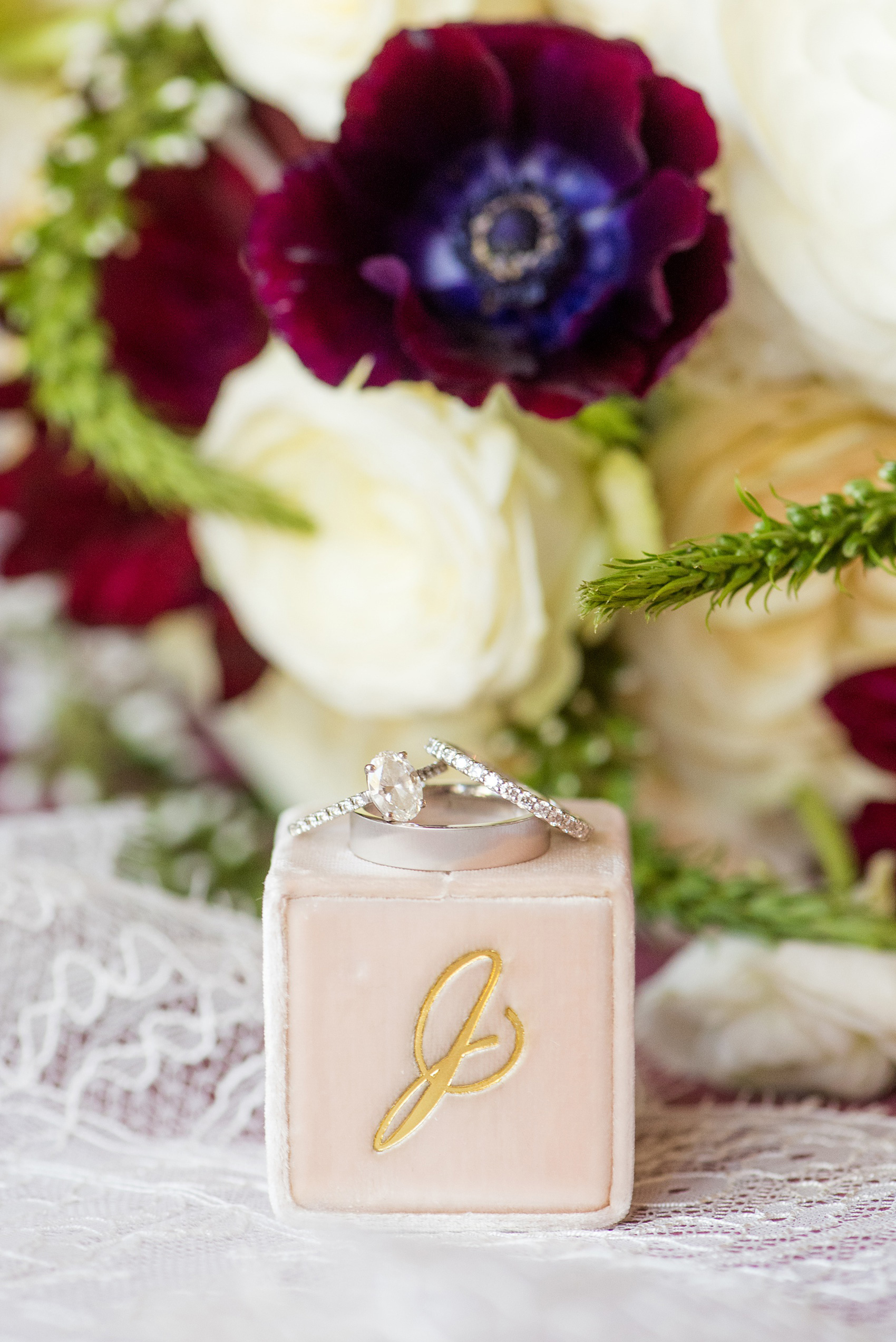 A fall wedding with burgundy, dusty rose and grey details. The couple's diamond rings, and bride's oval cut center stone engagement ring, were photographed with a pink Mrs. Box. Mikkel Paige Photography, photographer in Greenville NC and Raleigh captured this wedding at Rock Springs Center, planned by @vivalevent. Click through for more details and pictures from this autumn day! #mikkelpaige #northcarolinawedding #southernwedding #burgundywedding #themrsbox #velvetringbox #diamondrings