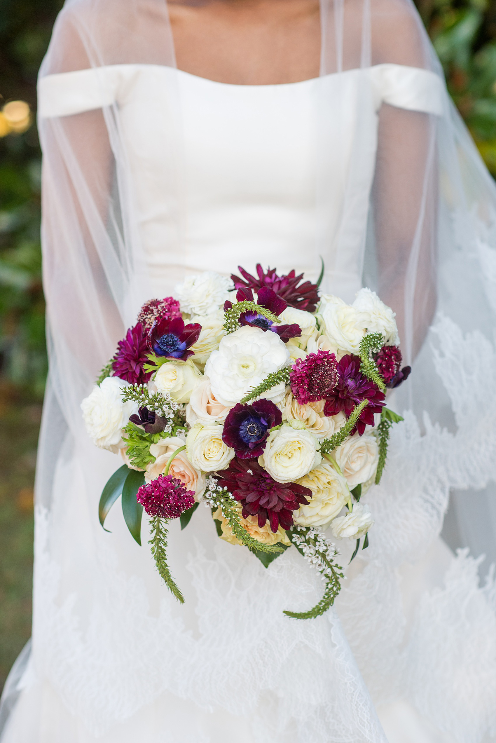 A fall wedding with burgundy, dusty rose and grey details. The bride carried a white and burgundy seasonal bouquet with scabiosas, dahlias, roses and ranunculus. Mikkel Paige Photography, photographer in Greenville NC and Raleigh captured this wedding at Rock Springs Center, planned by @vivalevent. Click through for more details and pictures from this autumn day! #mikkelpaige #northcarolinawedding #southernwedding #burgundywedding #fallbouquet #dahlias #ranunculus