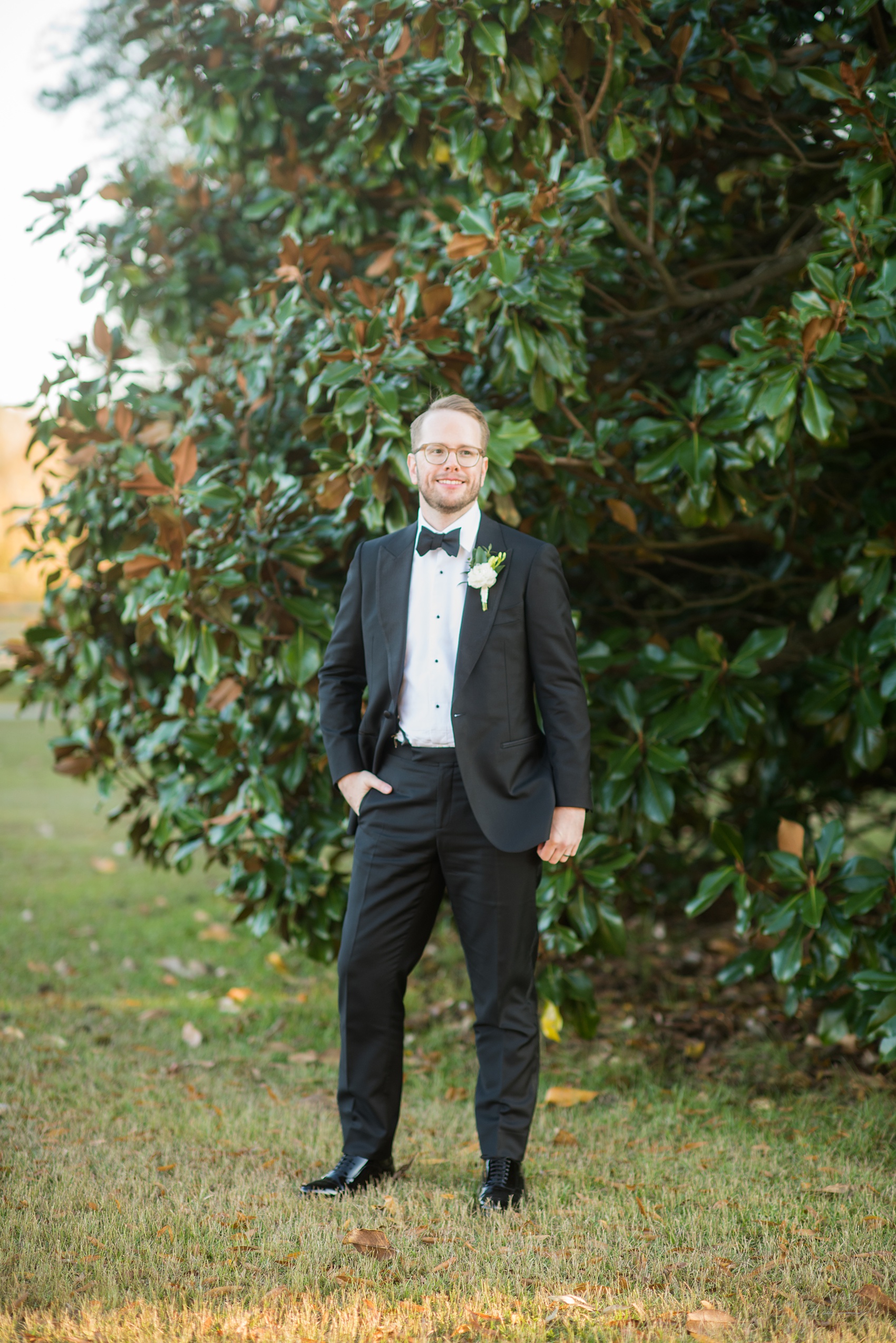 A fall wedding with burgundy, dusty rose and grey details. The groom wore a white ranunculus boutonniere and timeless black tuxedo and bow tie. Mikkel Paige Photography, photographer in Greenville NC and Raleigh captured this wedding at Rock Springs Center, planned by @vivalevent. Click through for more details and pictures from this autumn day! #mikkelpaige #northcarolinawedding #southernwedding #burgundywedding #fallbouquet #groomstyle #tuxedo #ranunculus #boutonniere