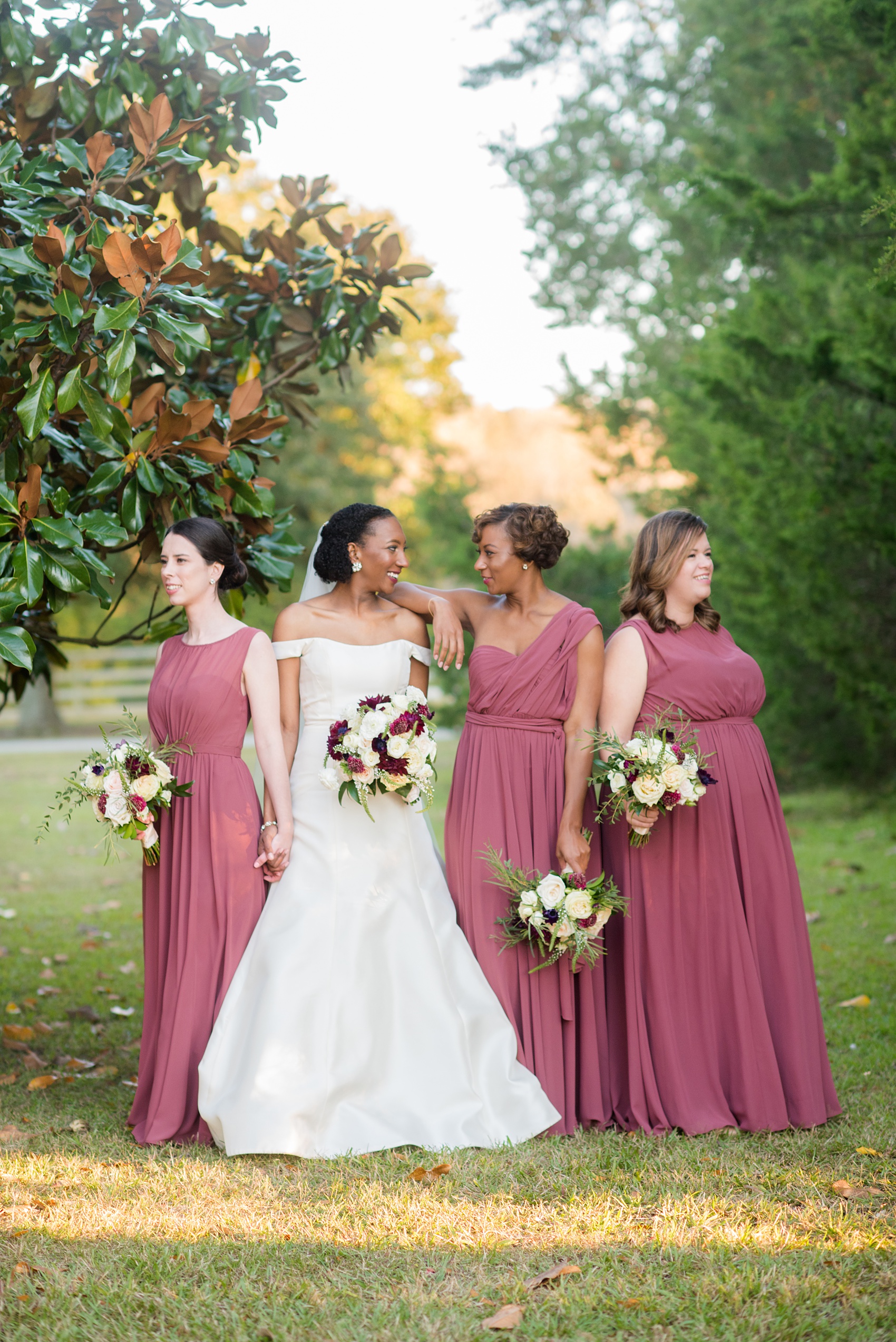 A fall wedding with burgundy, dusty rose and grey details. The bride and groom had three bridesmaids and groomsmen each, with the bridesmaids in cinnamon colored gowns and groomsmen in tuxedos. Mikkel Paige Photography, photographer in Greenville NC and Raleigh captured this wedding at Rock Springs Center, planned by @vivalevent. Click through for more details and pictures from this autumn celebration! #mikkelpaige #northcarolinawedding #southernwedding #bridesmaids#weddingparty #bridalparty