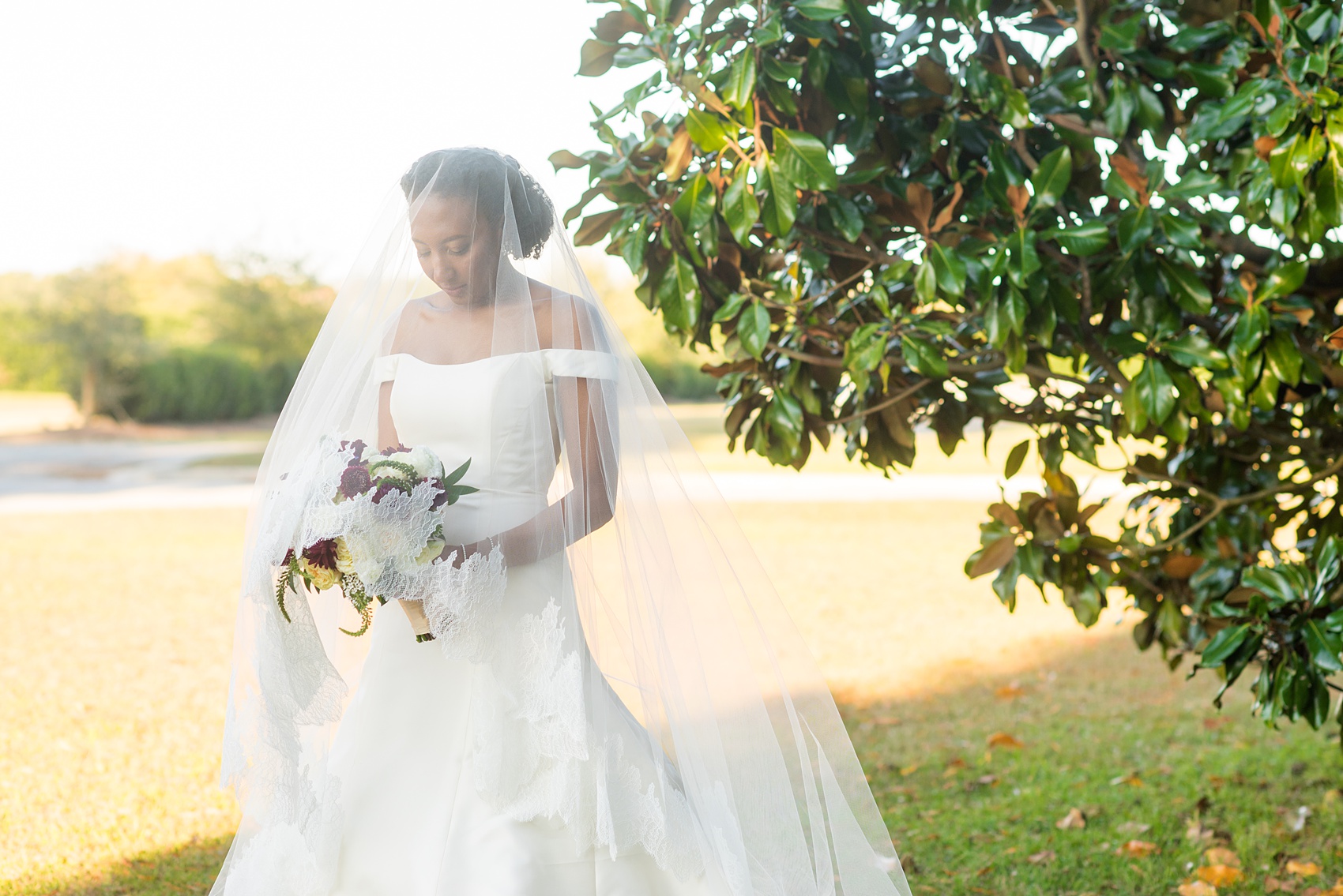 A fall wedding with burgundy, dusty rose and grey details. The bride wore an off-the-shoulder Anne Barge dress with a long veil that extended past her train. Mikkel Paige Photography, photographer in Greenville NC and Raleigh captured this wedding at Rock Springs Center, planned by @vivalevent. Click through for more details and pictures from this autumn day! #mikkelpaige #northcarolinawedding #southernwedding #burgundywedding #offtheshouldergown #annebarge #offtheshoulder #bridestyle