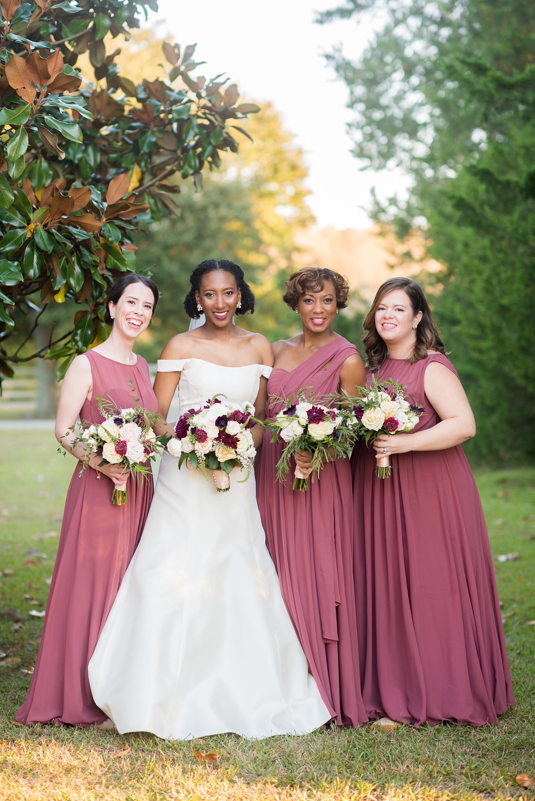 A fall wedding with burgundy, dusty rose and grey details. The bride and groom had three bridesmaids and groomsmen each, with the bridesmaids in cinnamon colored gowns and groomsmen in tuxedos. Mikkel Paige Photography, photographer in Greenville NC and Raleigh captured this wedding at Rock Springs Center, planned by @vivalevent. Click through for more details and pictures from this autumn celebration! #mikkelpaige #northcarolinawedding #southernwedding #bridesmaids#weddingparty #bridalparty